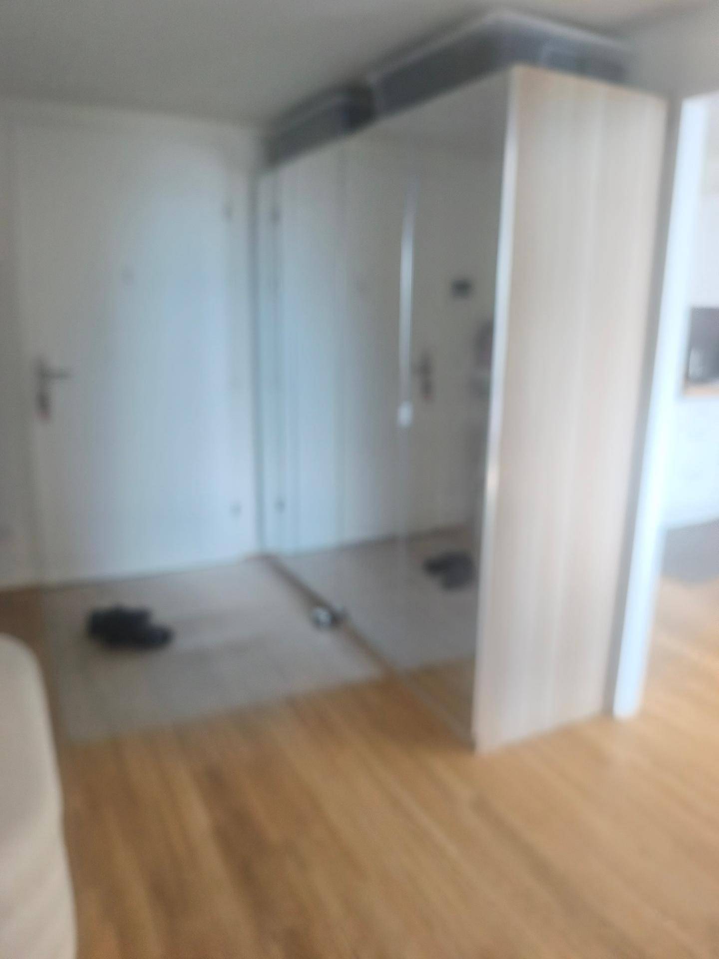 Innenraum mit begrenzter Sichtbarkeit und unscharfen Details, der den Holzboden zeigt.
