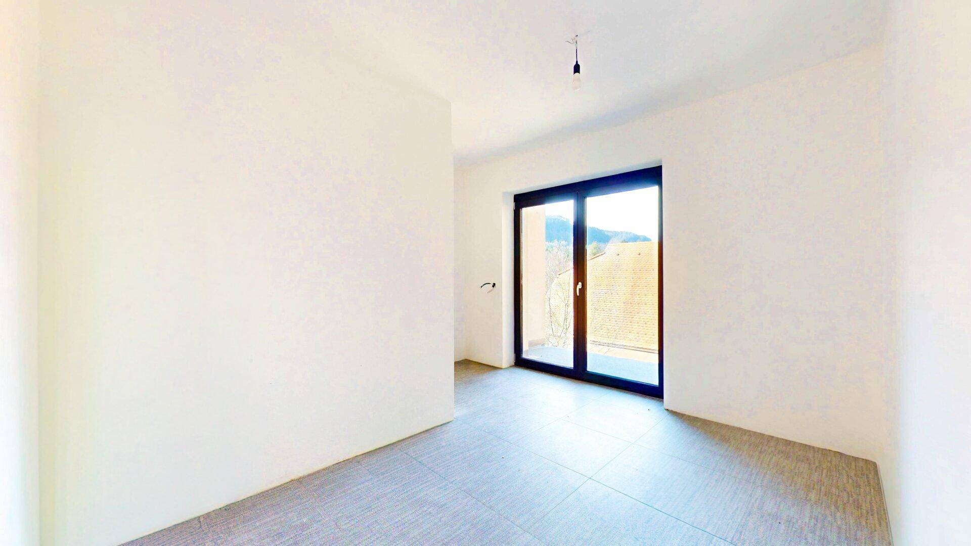 Helles Zimmer mit Zugang zu einem Balkon und Blick auf die grüne Umgebung, ideal als Schlafzimmer.
