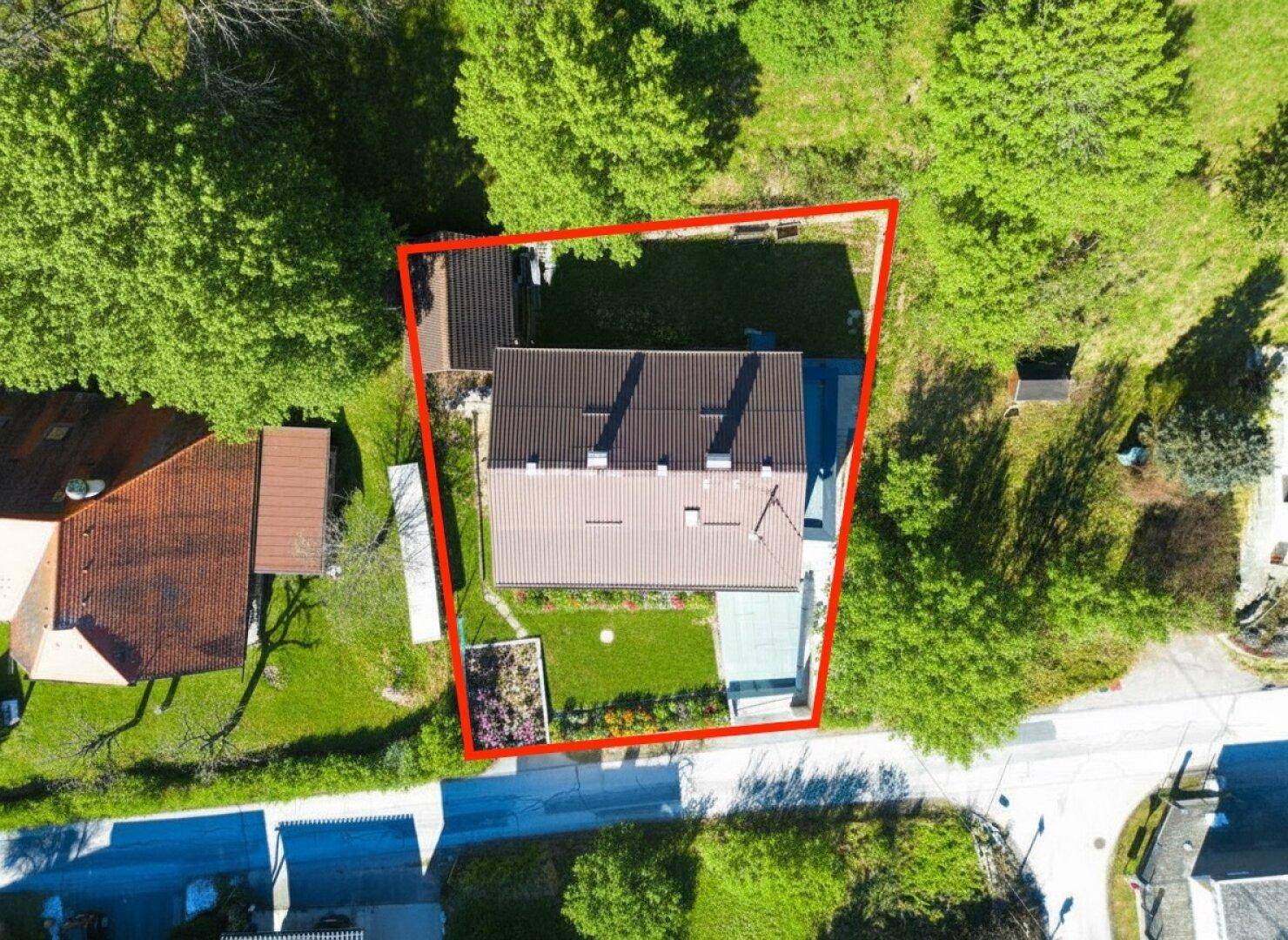 Vogelperspektive des Hauses mit Garten, umgeben von Bäumen und einer ruhigen Wohngegend.