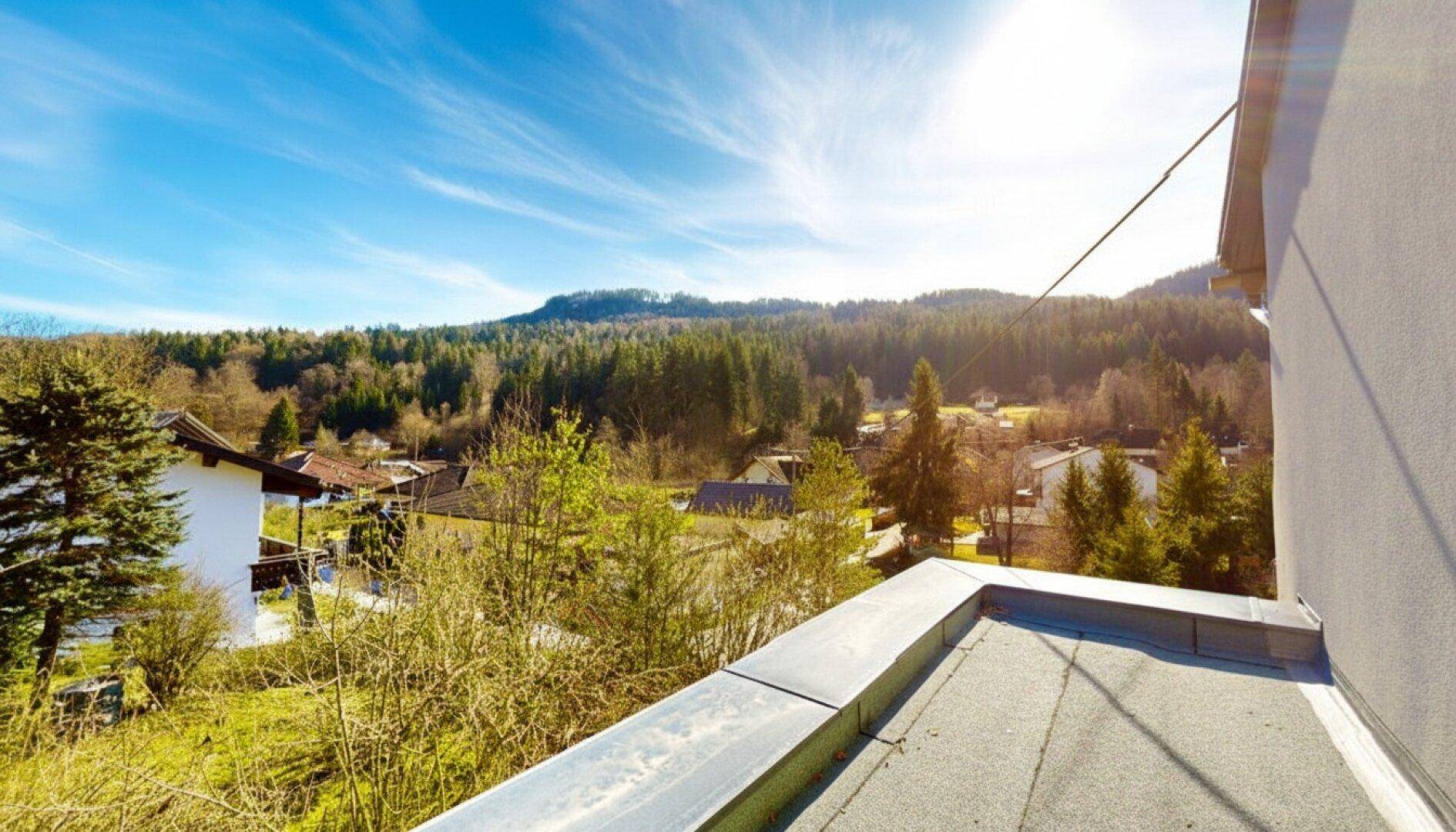 Weitläufiger Panoramablick über die grüne Hügellandschaft unter strahlend blauem Himmel.