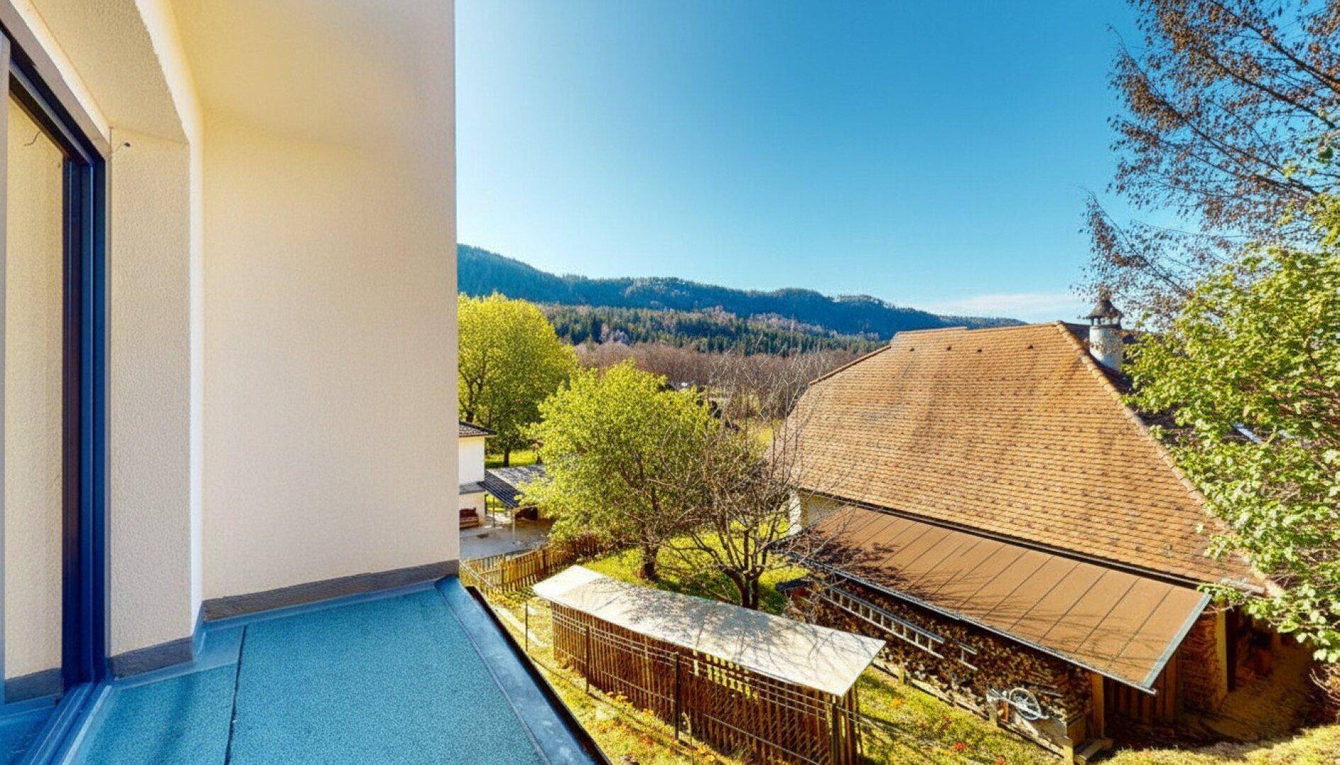 Kleiner Balkon mit Blick auf ein traditionelles Bauernhaus und die umliegende Natur.
