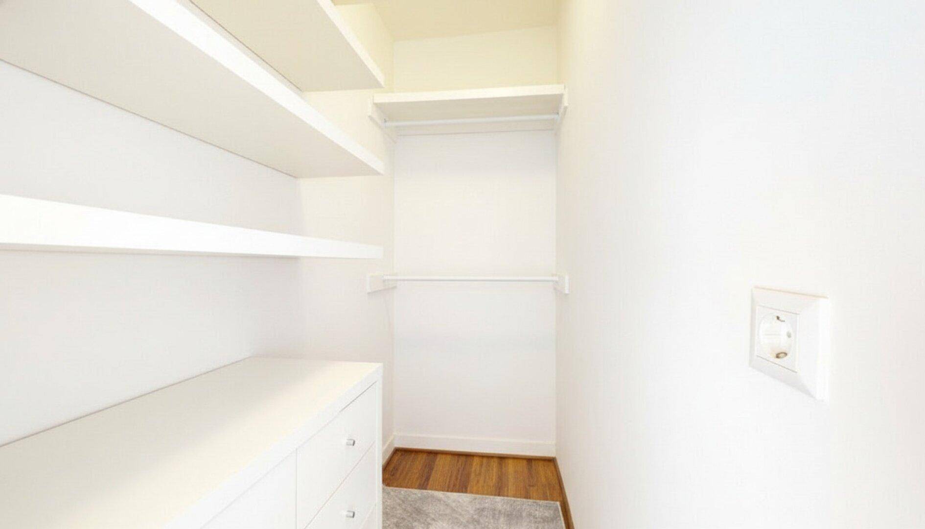 Praktischer begehbarer Kleiderschrank mit Regalen und Schubladen für viel Stauraum.