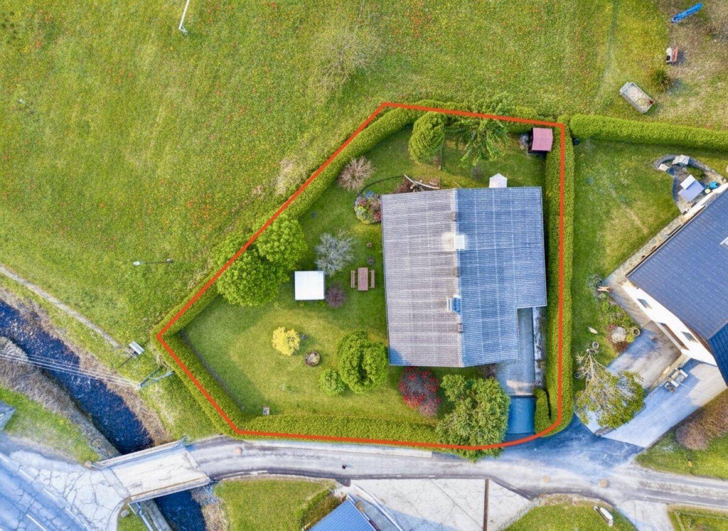 Vogelperspektive des Hauses mit großem Garten und umgebender Natur.