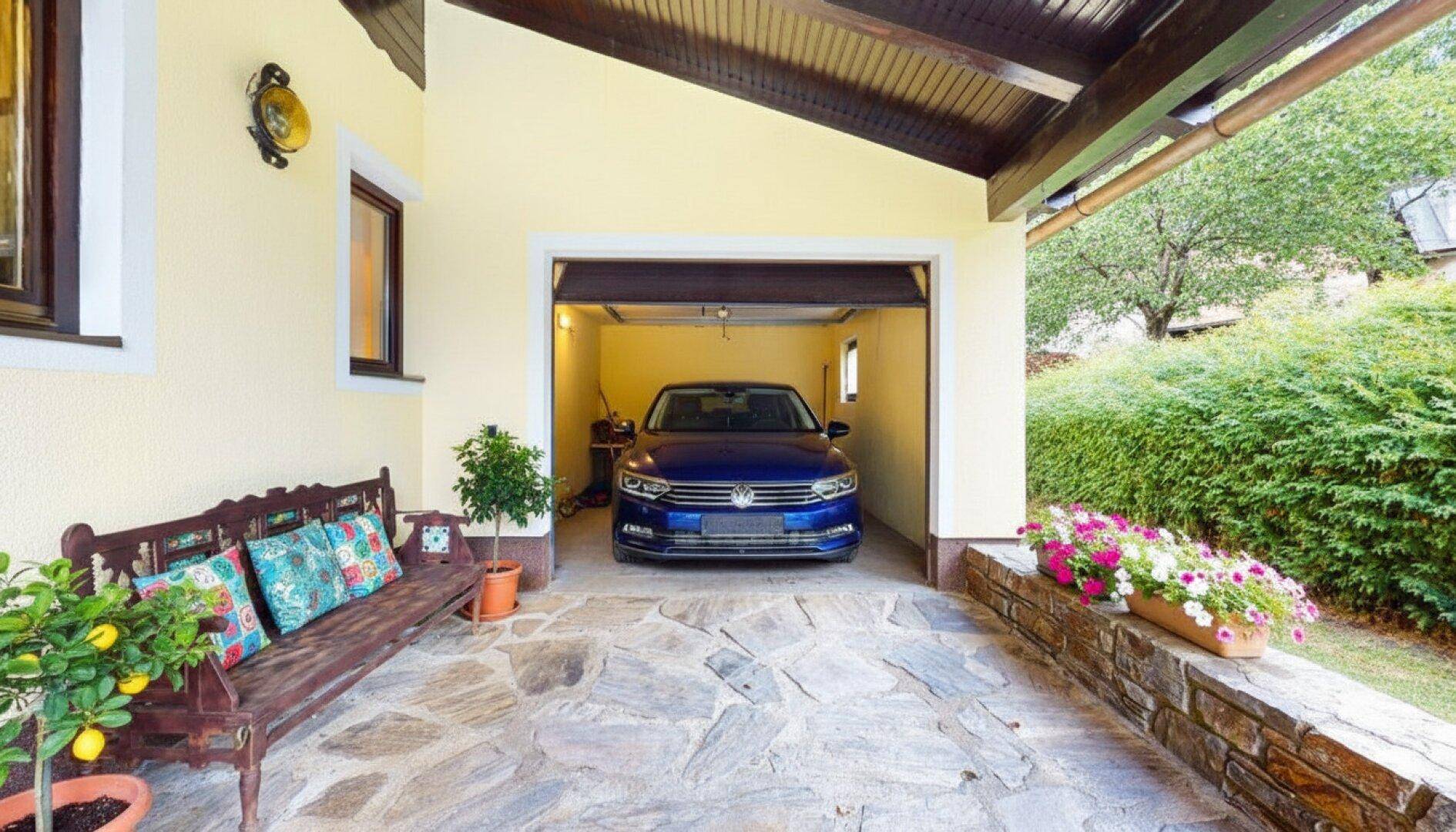 Überdachter Garagenbereich mit Stellplatz für ein Fahrzeug und angrenzender Sitzbank.