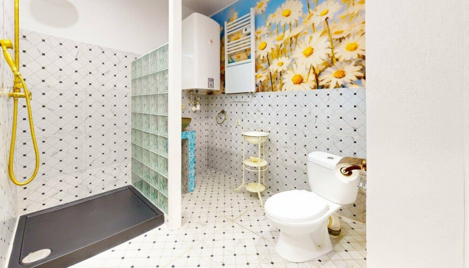 Helles Badezimmer mit Dusche, karierten Fliesen und floraler Wandgestaltung.