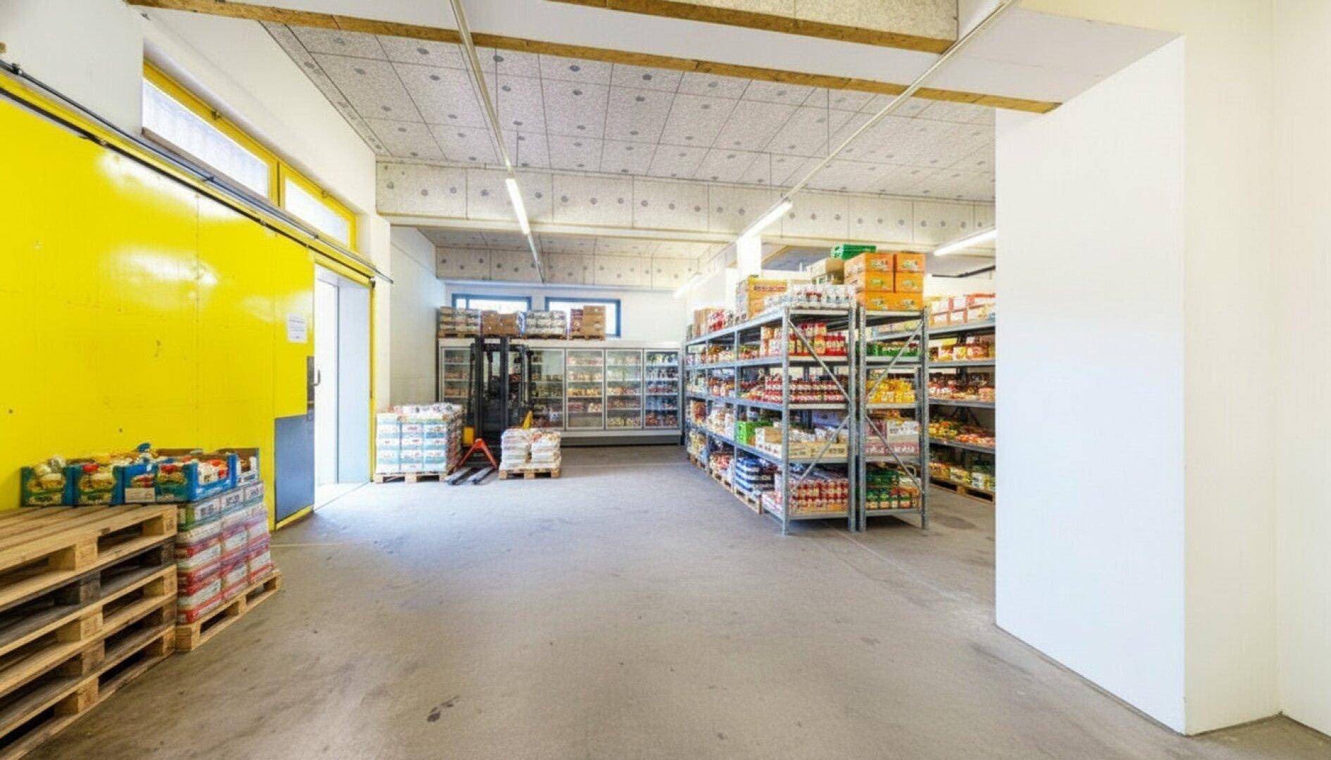Großer Lagerraum mit Regalen, Paletten und einem Gabelstapler, ideal für gewerbliche Nutzung und Logistik.