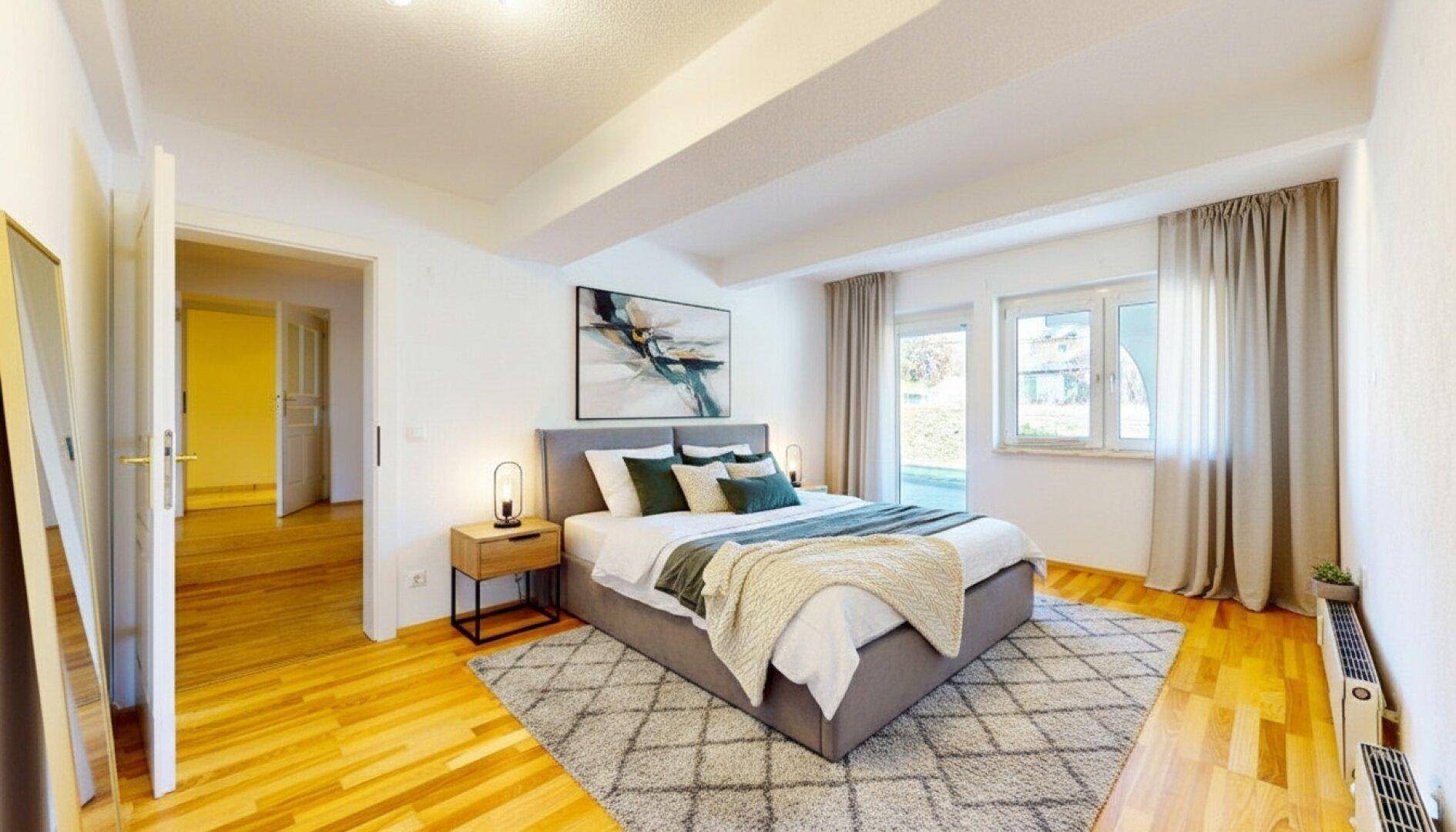 Gemütliches Schlafzimmer mit Holzboden, großem Bett und natürlichem Lichteinfall.