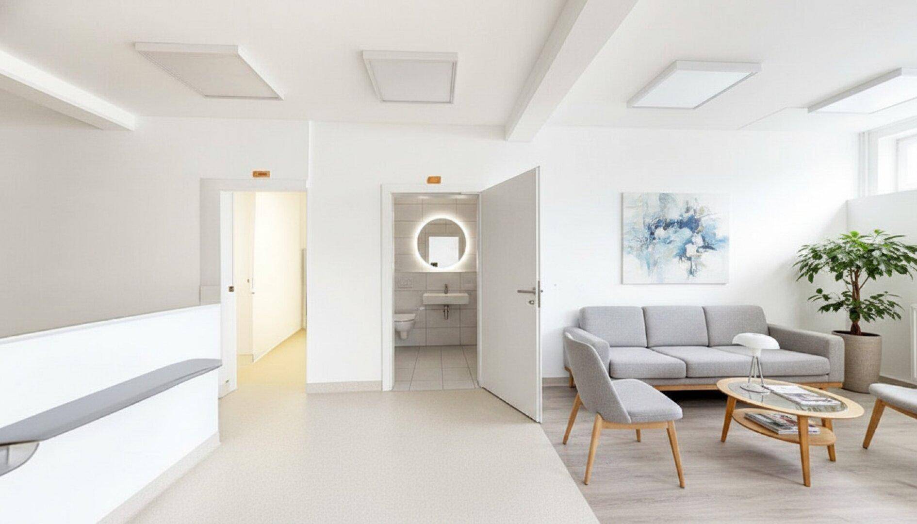 Heller Behandlungsraum mit einer Therapieliege, Sprossenwand und Vorhang für Privatsphäre.