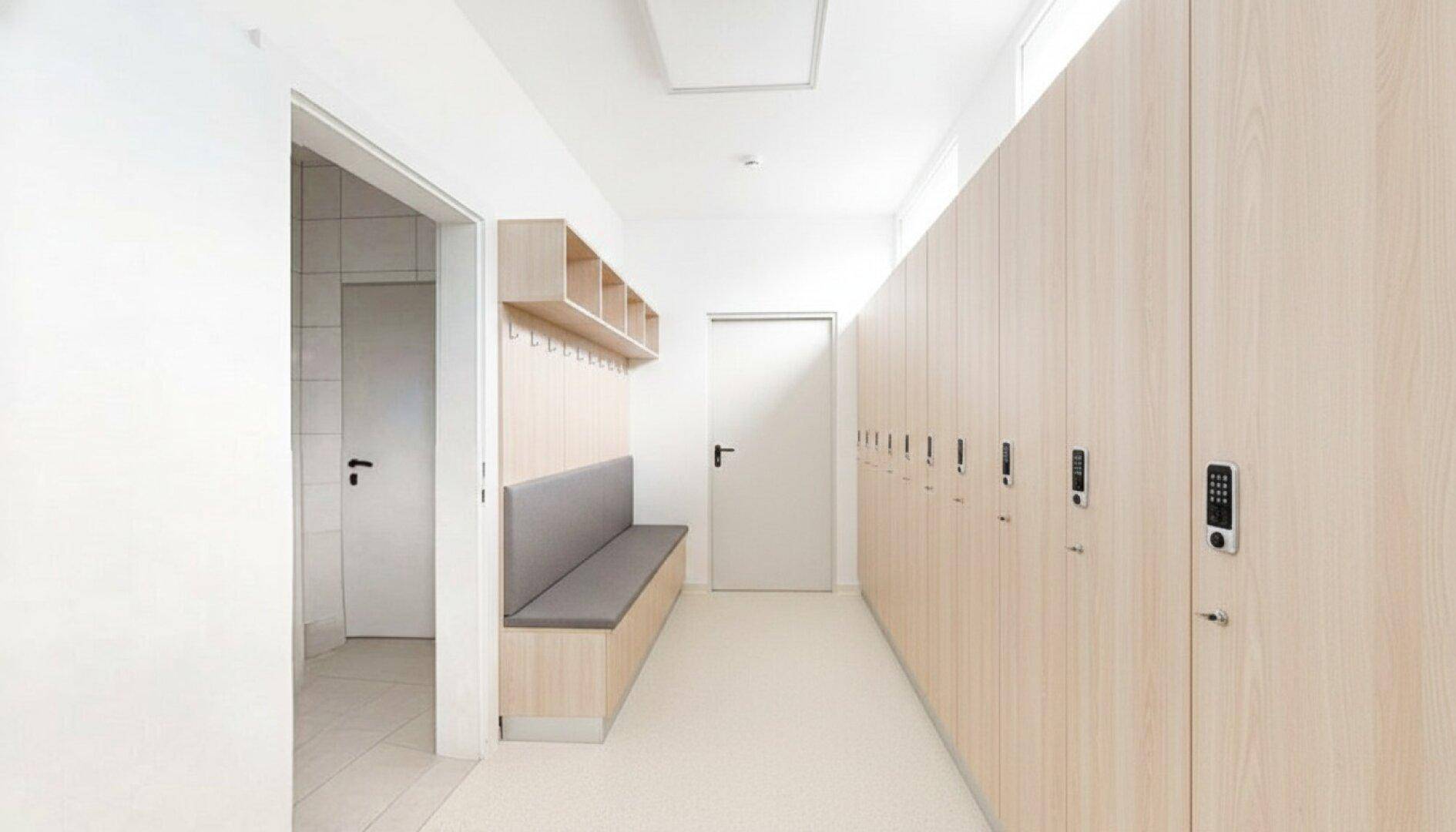 Modernes Badezimmer mit weißen Fliesen, beleuchtetem Spiegel und schwarzer Armatur.