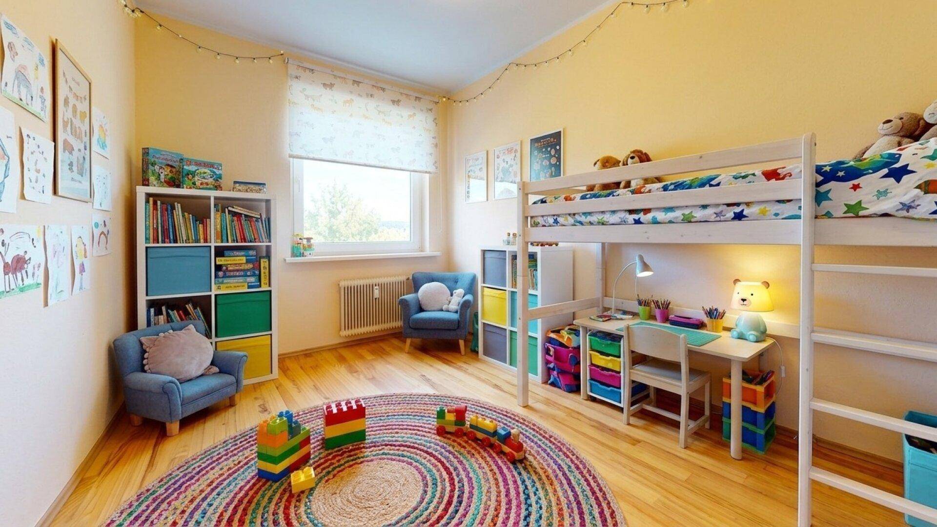 Farbenfrohes Kinderzimmer mit Hochbett, Schreibtisch, Spielteppich und viel Stauraum für Spielzeug.