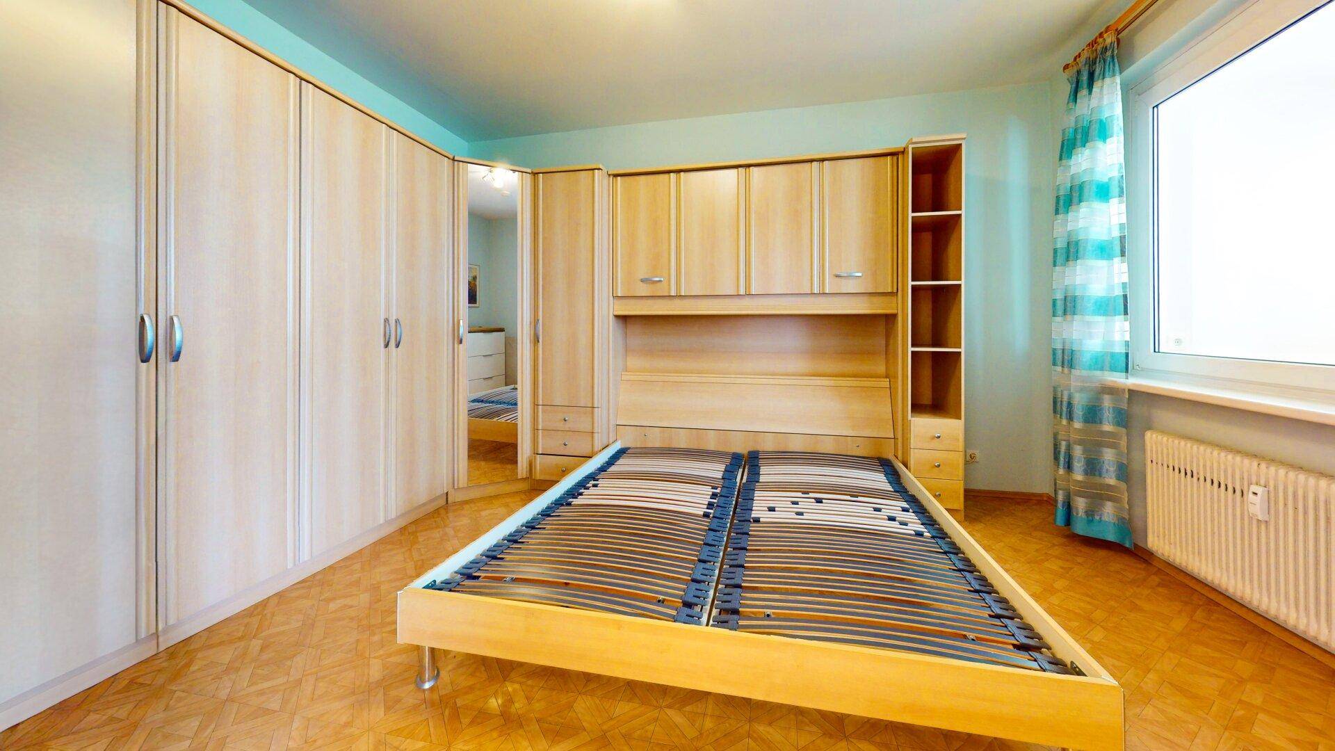 Schlafzimmer mit Holzboden, Einbauschränken und Bettgestell, bereit für persönliche Einrichtung und Komfort.