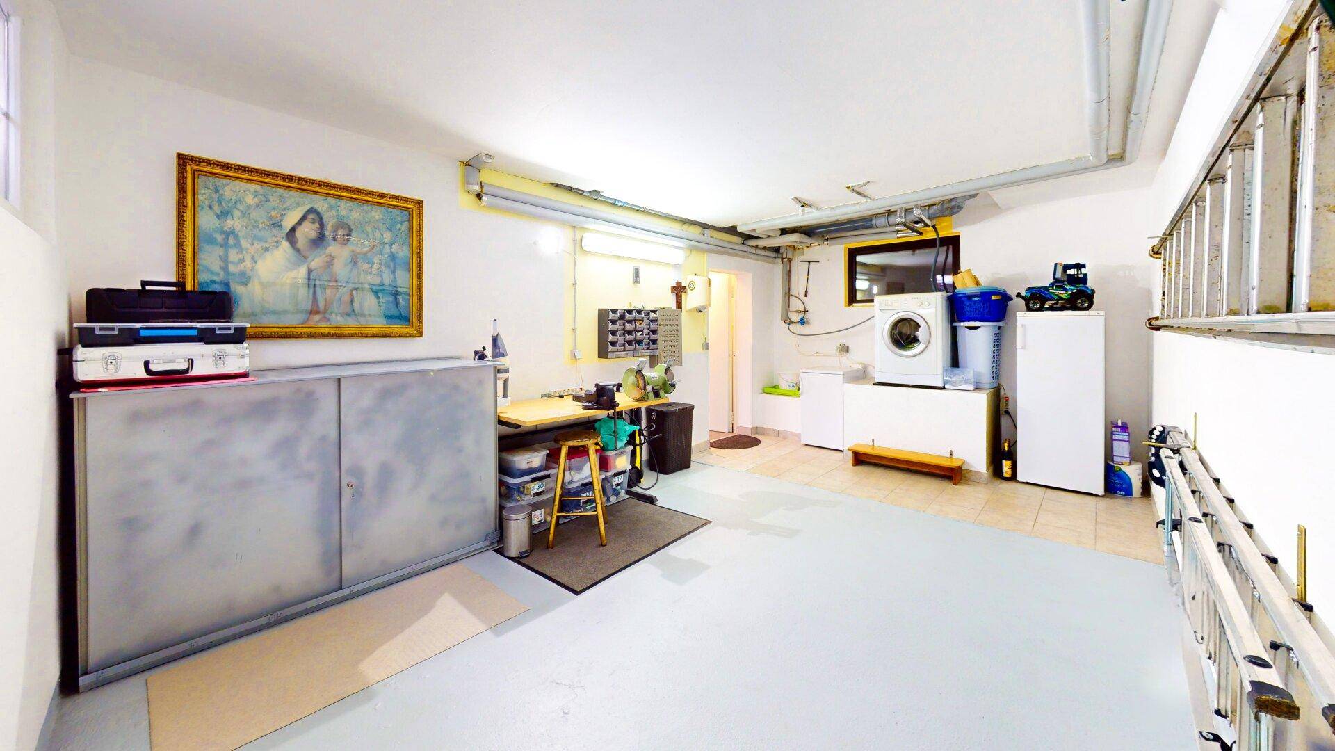 Geräumiger Hauswirtschaftsraum mit Waschmaschine, Arbeitsbereich und Stauraum.