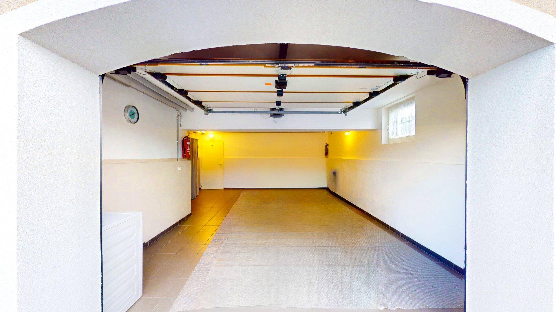Geräumige Garage mit ausreichend Platz für mehrere Fahrzeuge und Lagerungsmöglichkeiten.