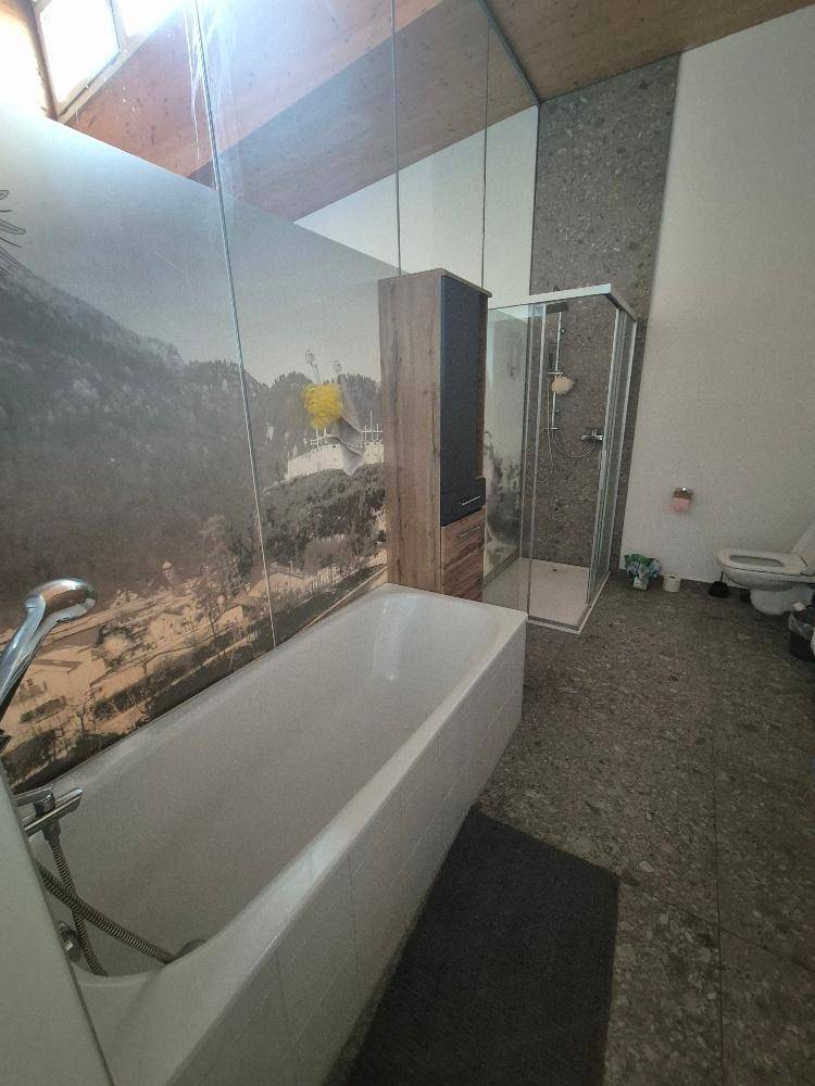 Modernes Badezimmer mit Badewanne, Duschkabine und einer beeindruckenden Wandtapete.