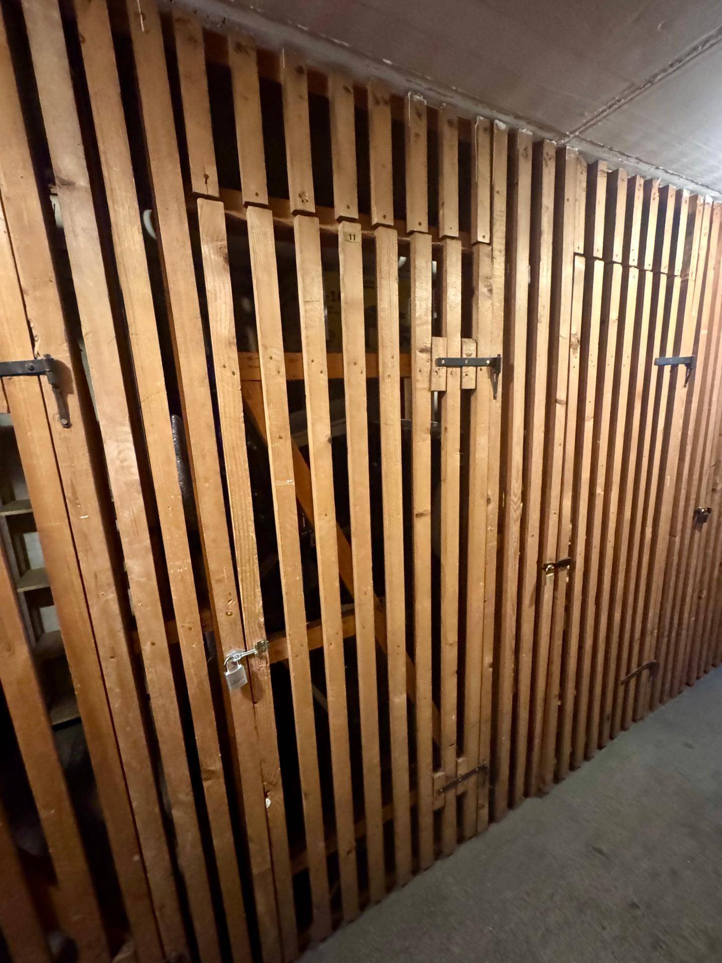 Kellerabteile mit Holzlattenwänden bieten praktischen Stauraum für Bewohner des Gebäudes.