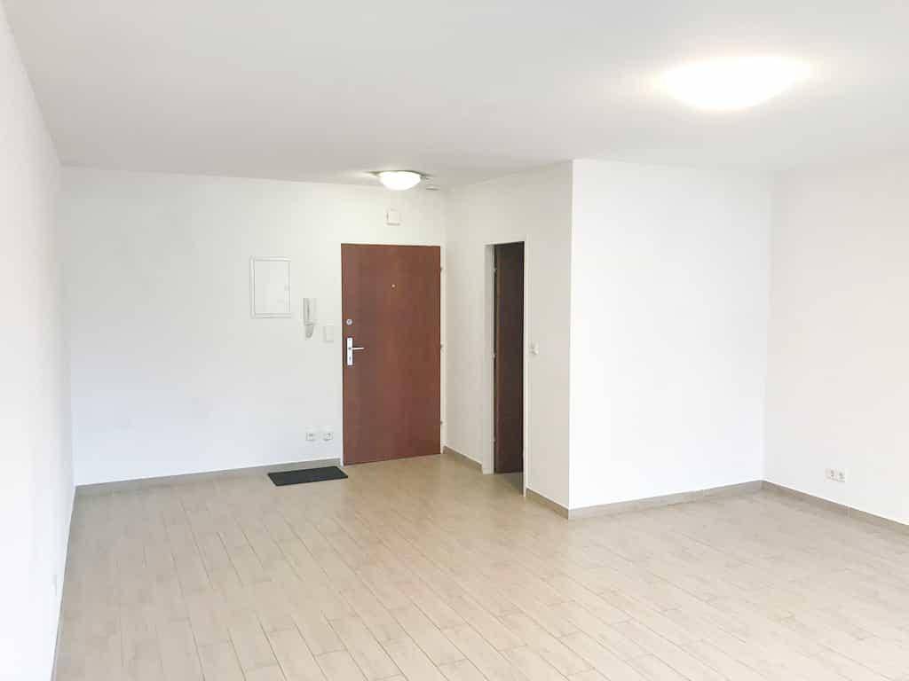 Heller Eingangsbereich mit Holzboden und weiß gestrichenen Wänden, bereit zur Einrichtung.