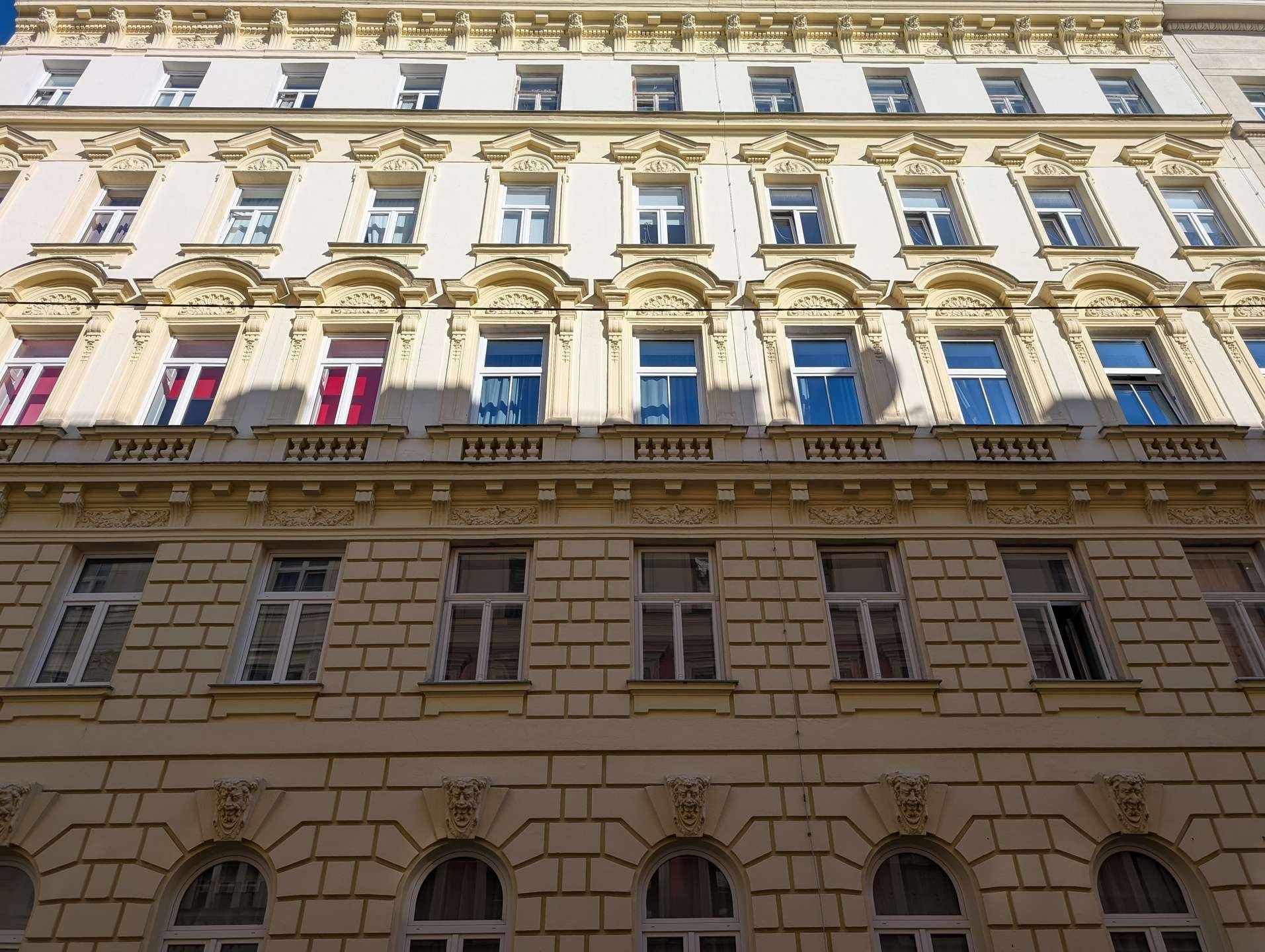 Historische Gebäudefassade mit vielen Fenstern und klassischen architektonischen Details.