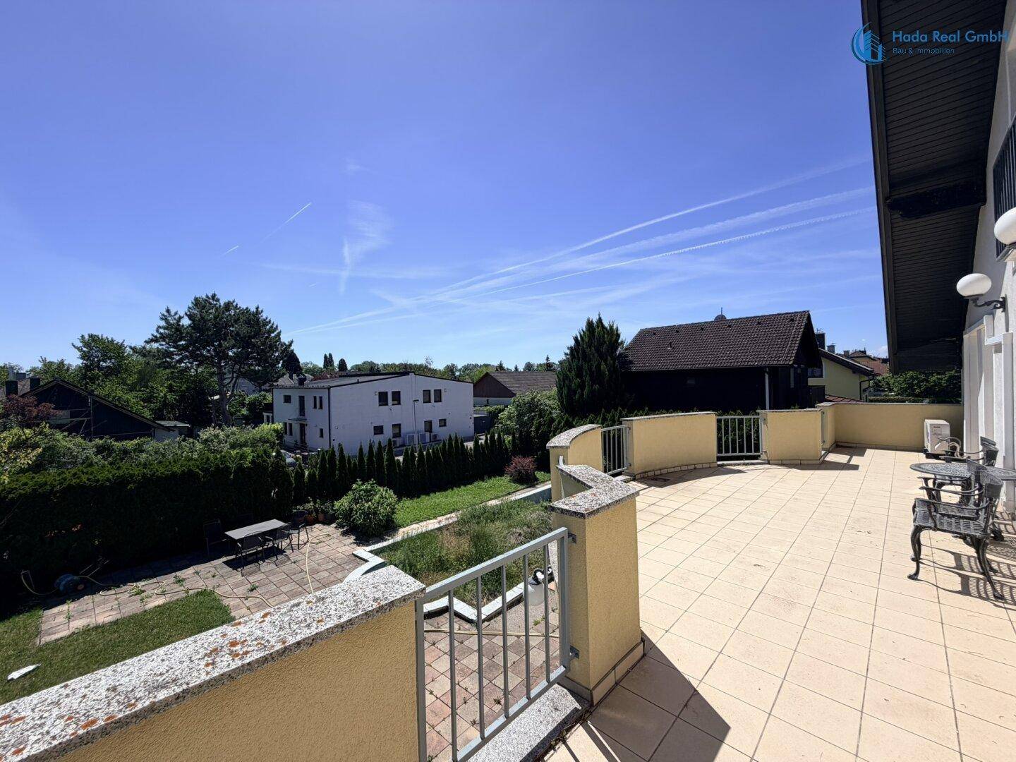 Panoramablick von der Terrasse auf die umliegende Nachbarschaft und den grünen Gartenbereich.