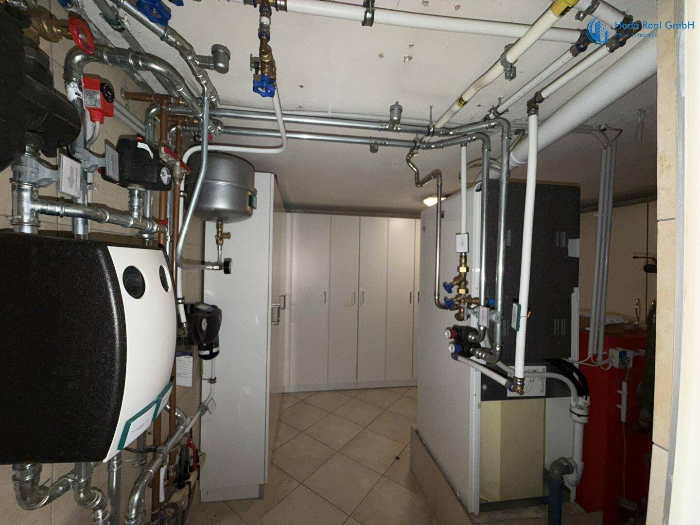 Technikraum mit zahlreichen Rohren, Warmwasserbereitern und praktischen Lagerschränken.