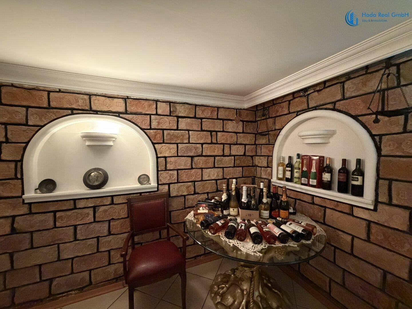 Detailansicht einer Hausbar mit Weinflaschen und dekorativen Nischen in Ziegelwand.