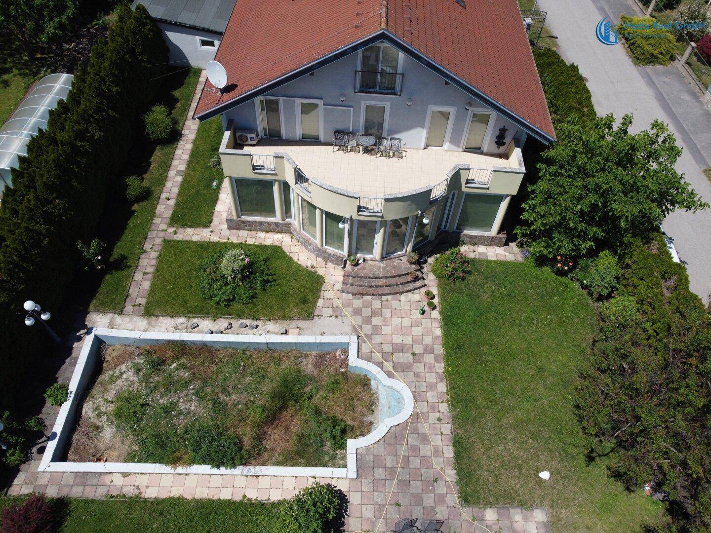 Vogelperspektive des Hauses mit weitläufigem Garten, Terrasse und Poolbereich.