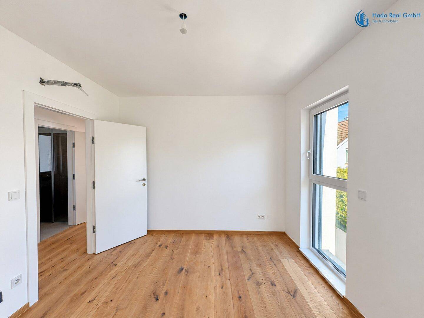 Geräumiges Zimmer mit Holzboden und Fenster, ideal als Schlaf- oder Kinderzimmer.