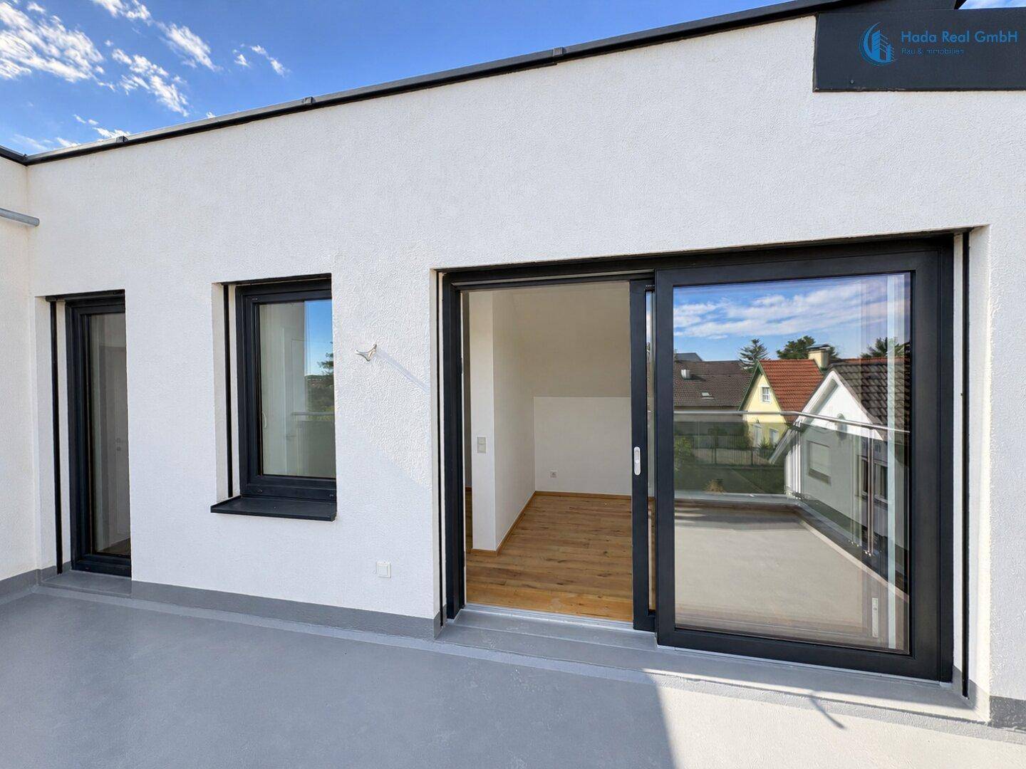Heller Balkon mit Schiebetüren, die direkten Zugang zu einem Innenraum bieten.