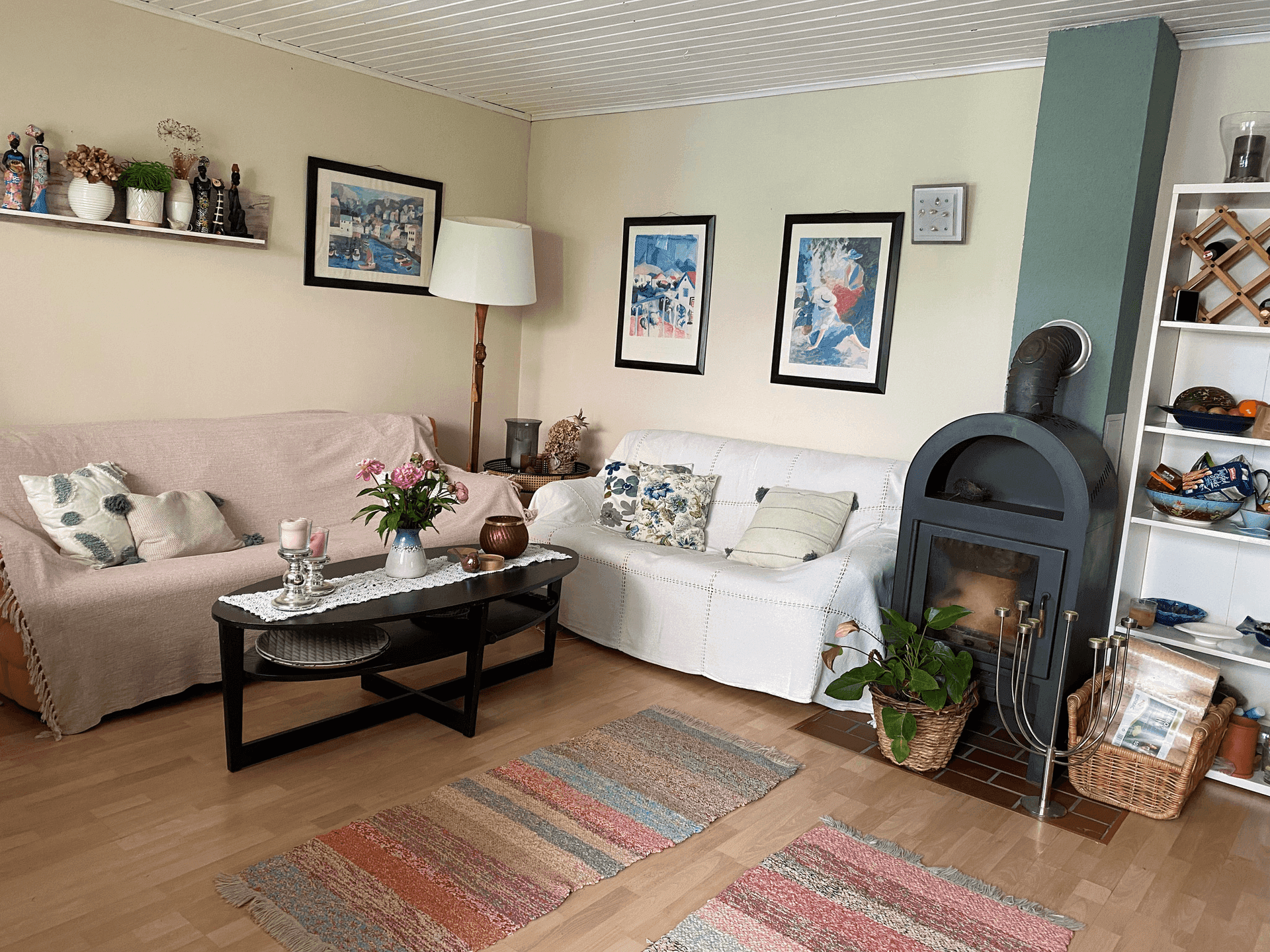 Helles Wohnzimmer mit Holzboden, zwei Sofas und einem modernen Kaminofen für gemütliche Abende.
