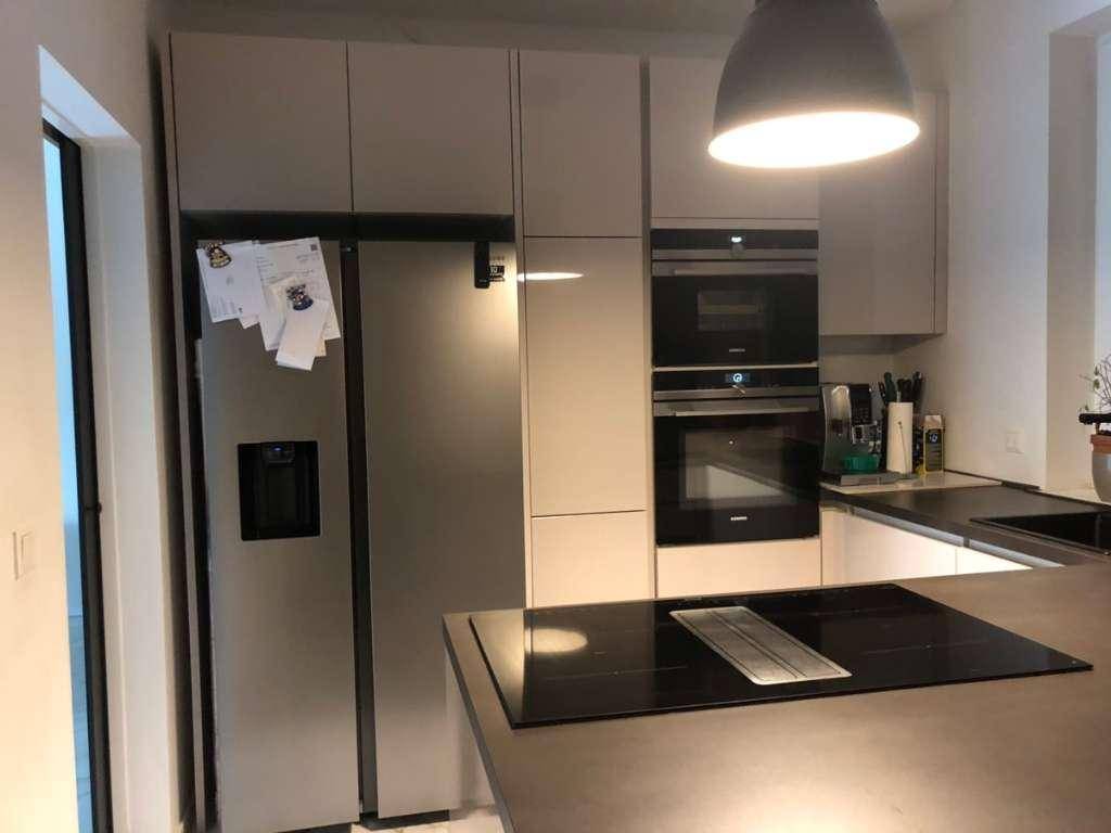 Moderne Küche mit integrierten Geräten, großem Kühlschrank und Induktionskochfeld auf der Insel.