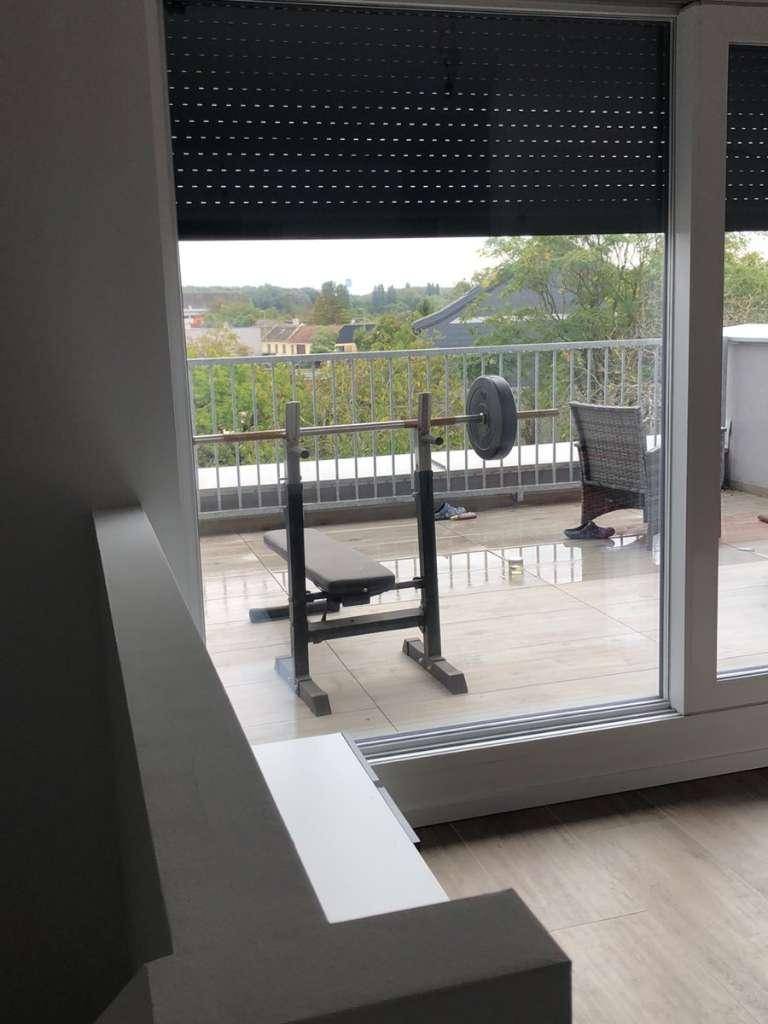 Terrasse mit Fitnessgeräten und Blick ins Grüne, ideal für Outdoor-Training und Entspannung.
