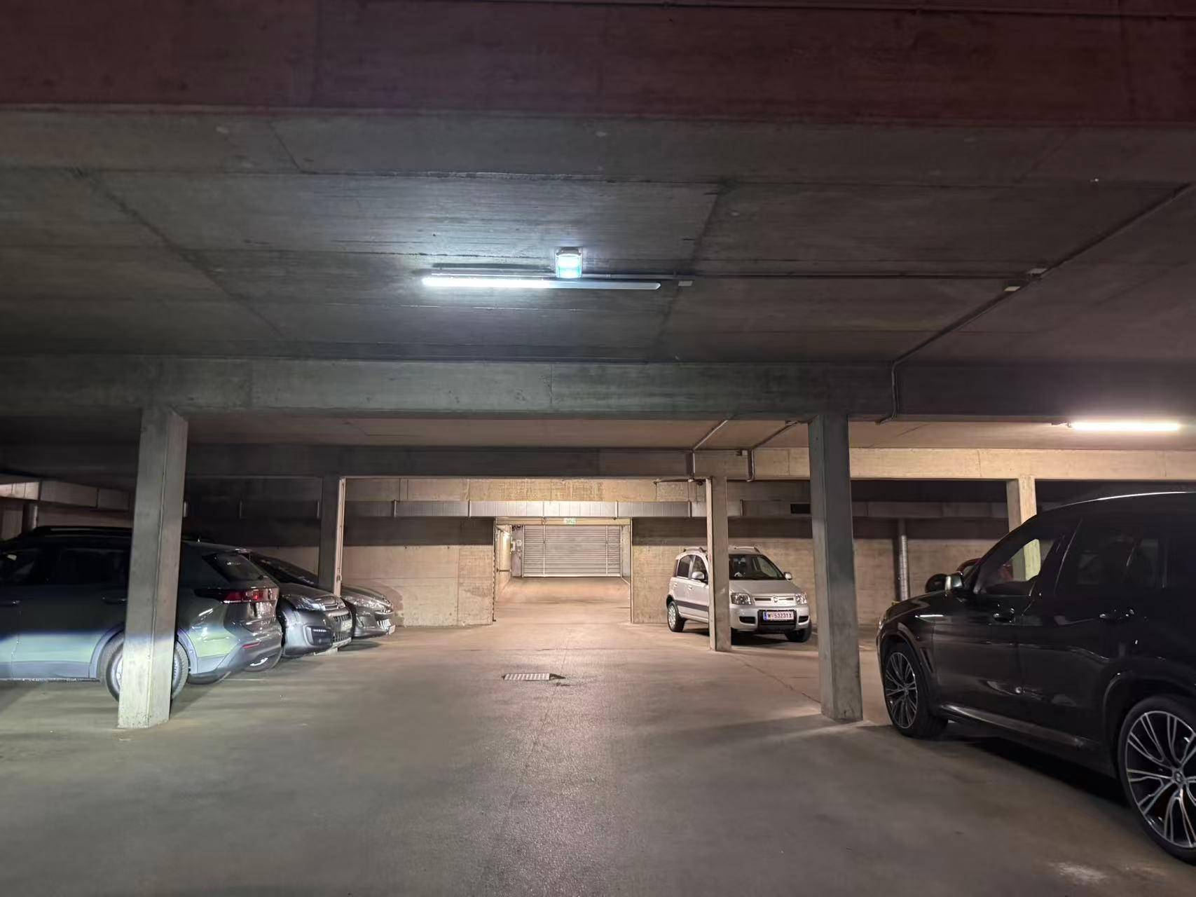 Helle Tiefgarage mit ausreichend Platz für Fahrzeuge und einfacher Zufahrt.