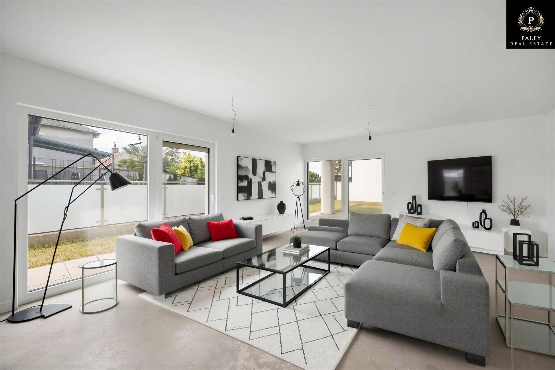 Modern eingerichtetes Wohnzimmer mit großen Fenstern, bequemen Sofas und minimalistischer Dekoration.