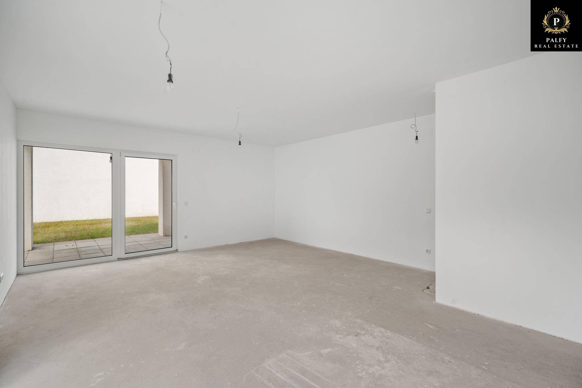 Heller, unmöblierter Wohnbereich im Rohbau mit großen Fenstern und direktem Terrassenzugang.