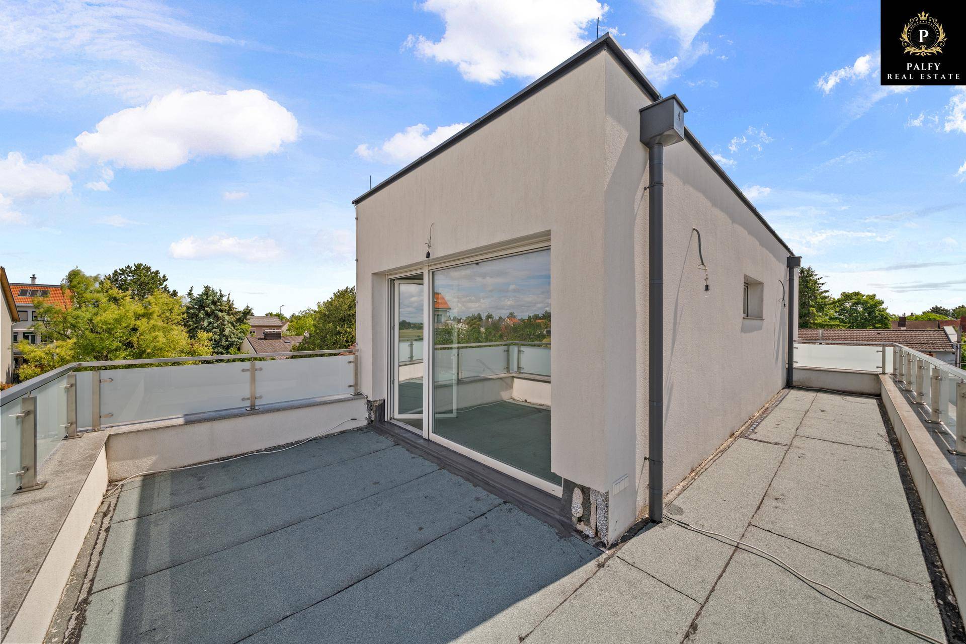Geräumige Dachterrasse mit Zugang zu einem Zimmer und weitem Ausblick auf die Umgebung.