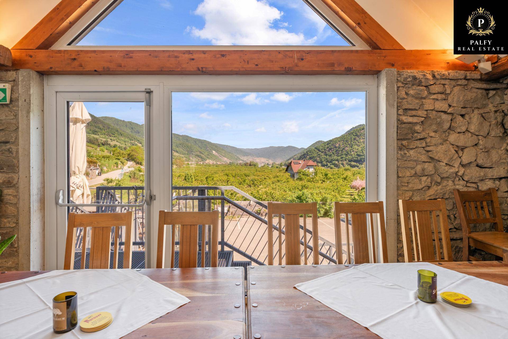 Speisesaal mit großen Fenstern, die einen weiten Blick auf die grüne Landschaft bieten.