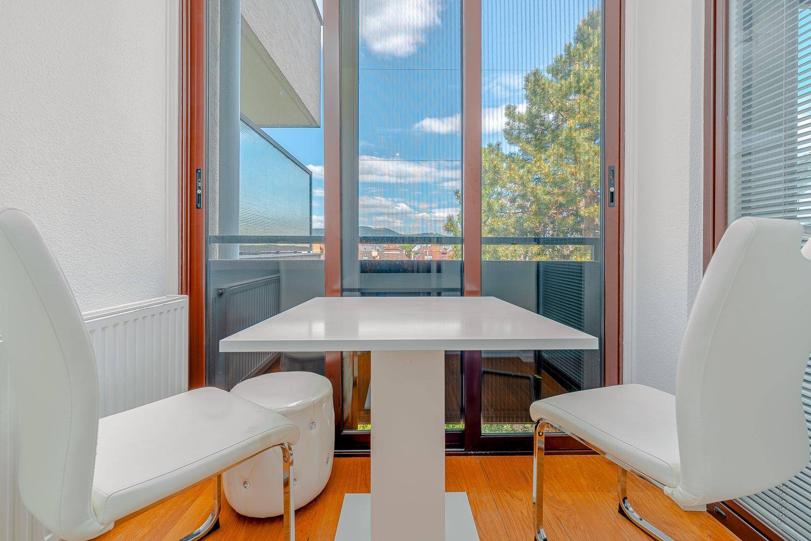 Gemütlicher Essbereich auf dem Balkon mit Tisch und Stühlen und weitem Blick.