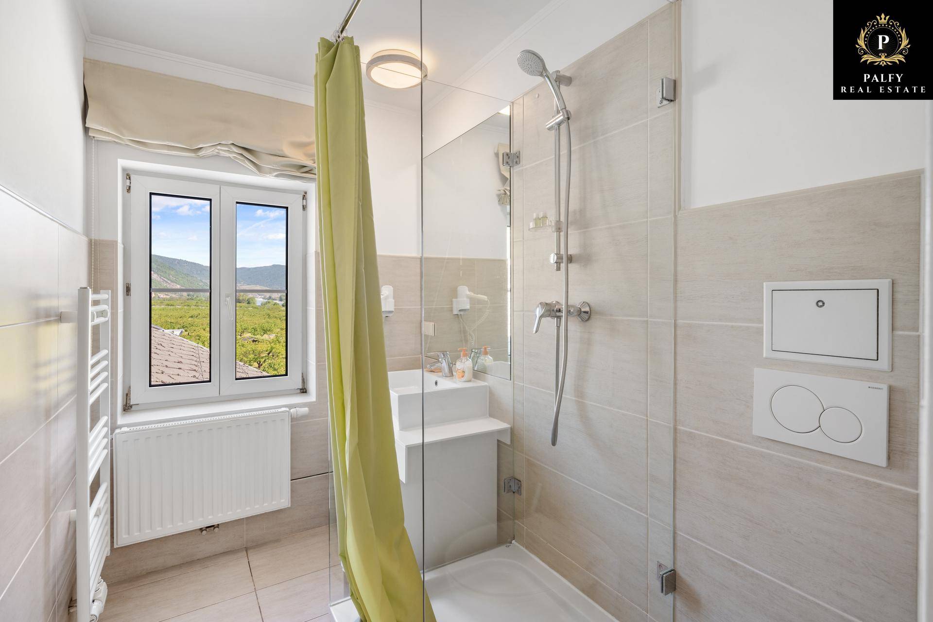 Modernes Badezimmer mit Duschkabine, Waschbecken und Fenster mit Landschaftsblick.