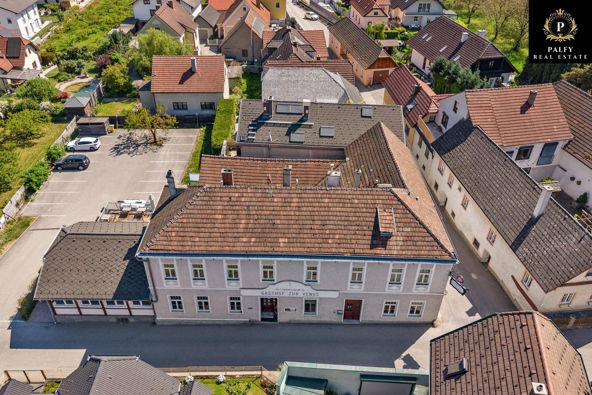 Dachansicht des Gasthofs "Gasthof zum Venus" mit Parkplatz und umliegenden Gebäuden.