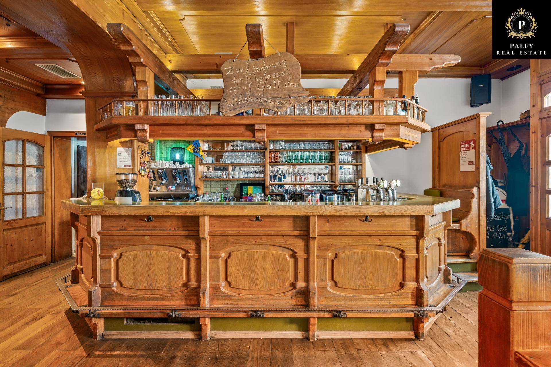 Rustikale Bar aus dunklem Holz mit Zapfanlage und vielen Gläsern, traditionell eingerichtet.