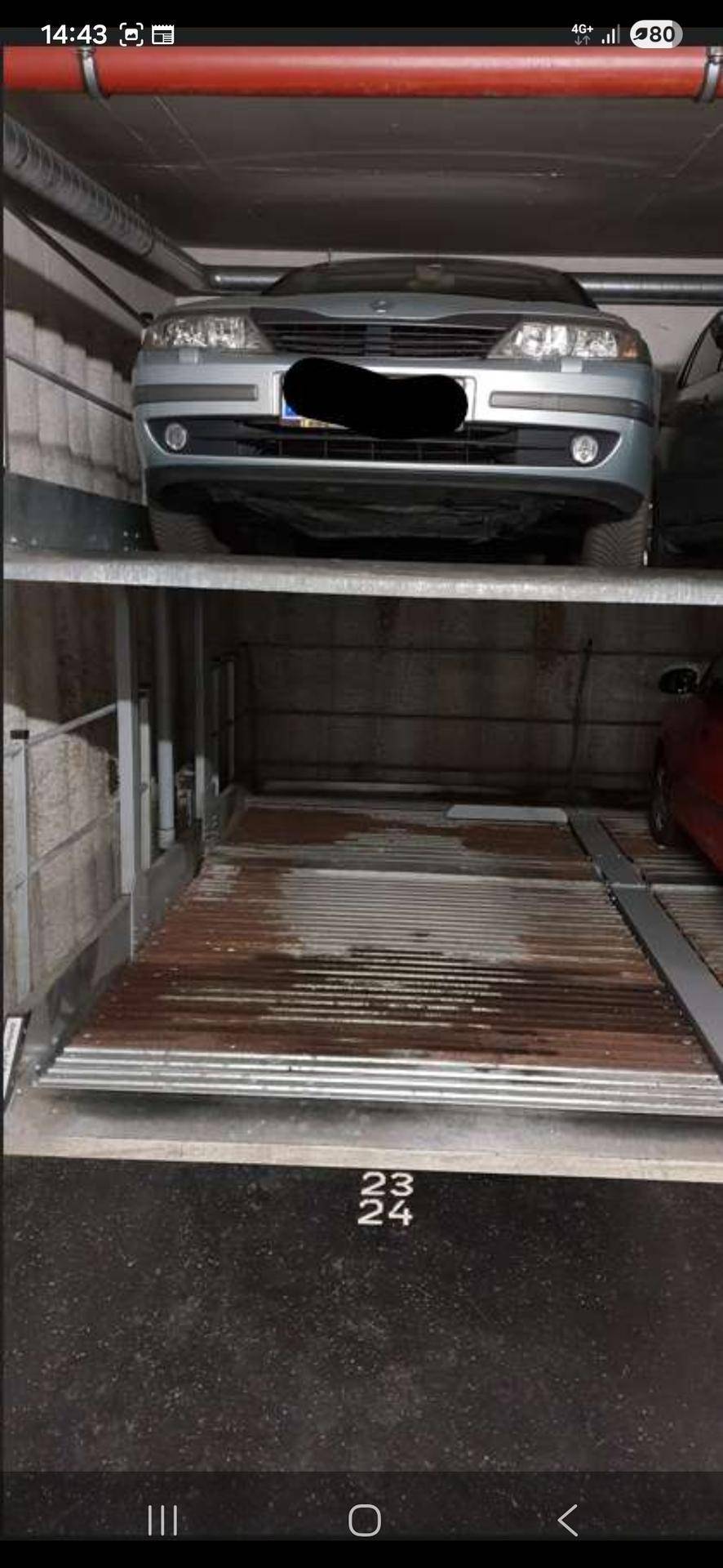 Nahaufnahme eines Doppelparker-Systems in der Tiefgarage mit einem Fahrzeug auf der oberen Plattform.
