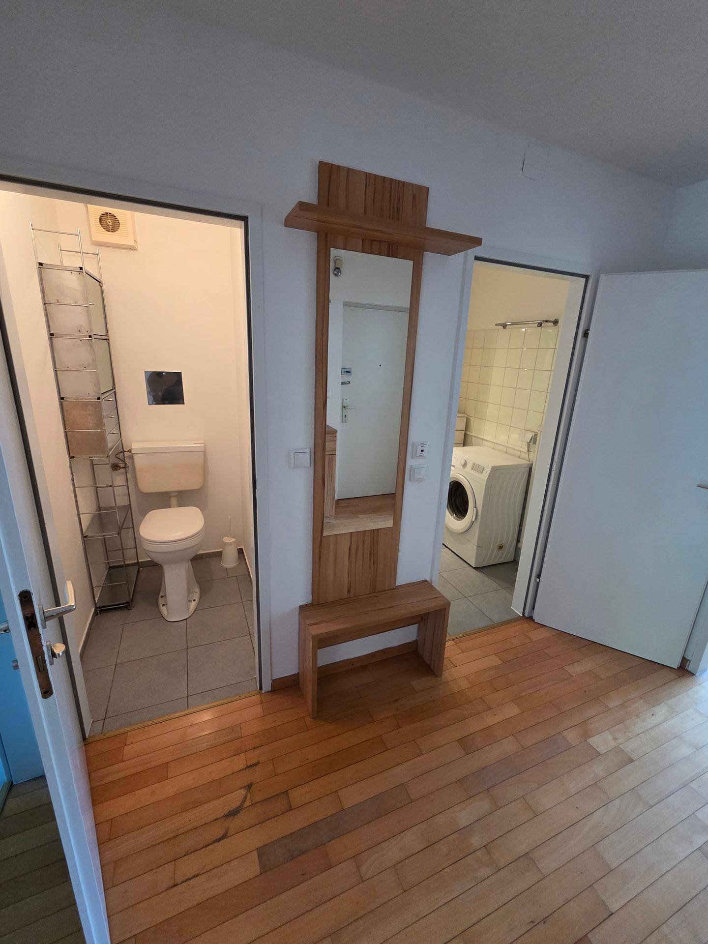 Flur mit Holzboden und Zugang zu separatem WC und Waschküche.