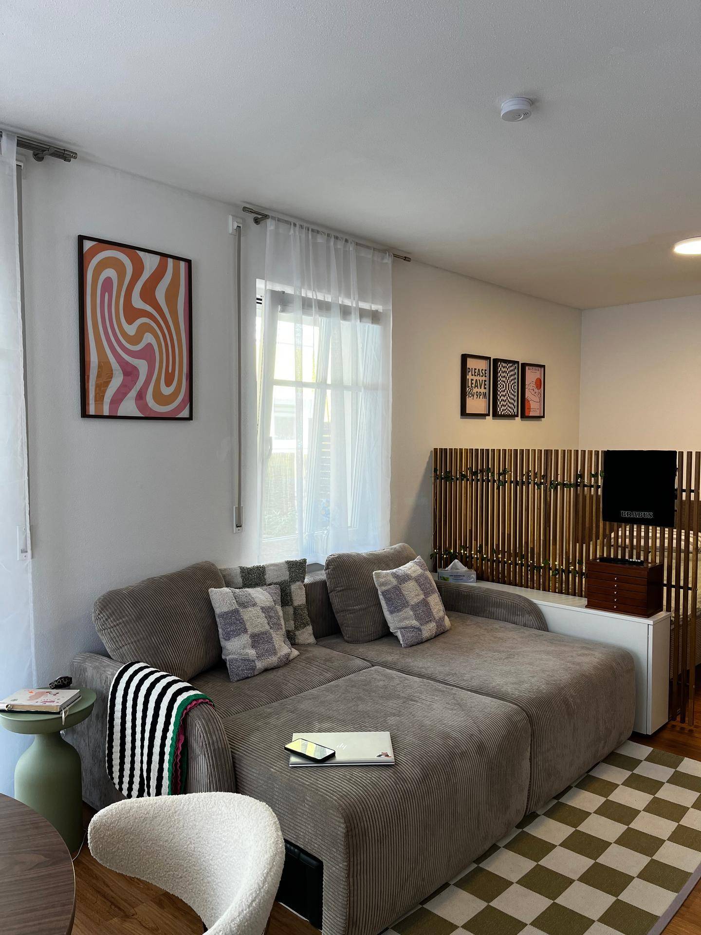 Wohnzimmer mit großem Ecksofa, dekorativen Kissen und einem karierten Teppich für entspannte Stunden.