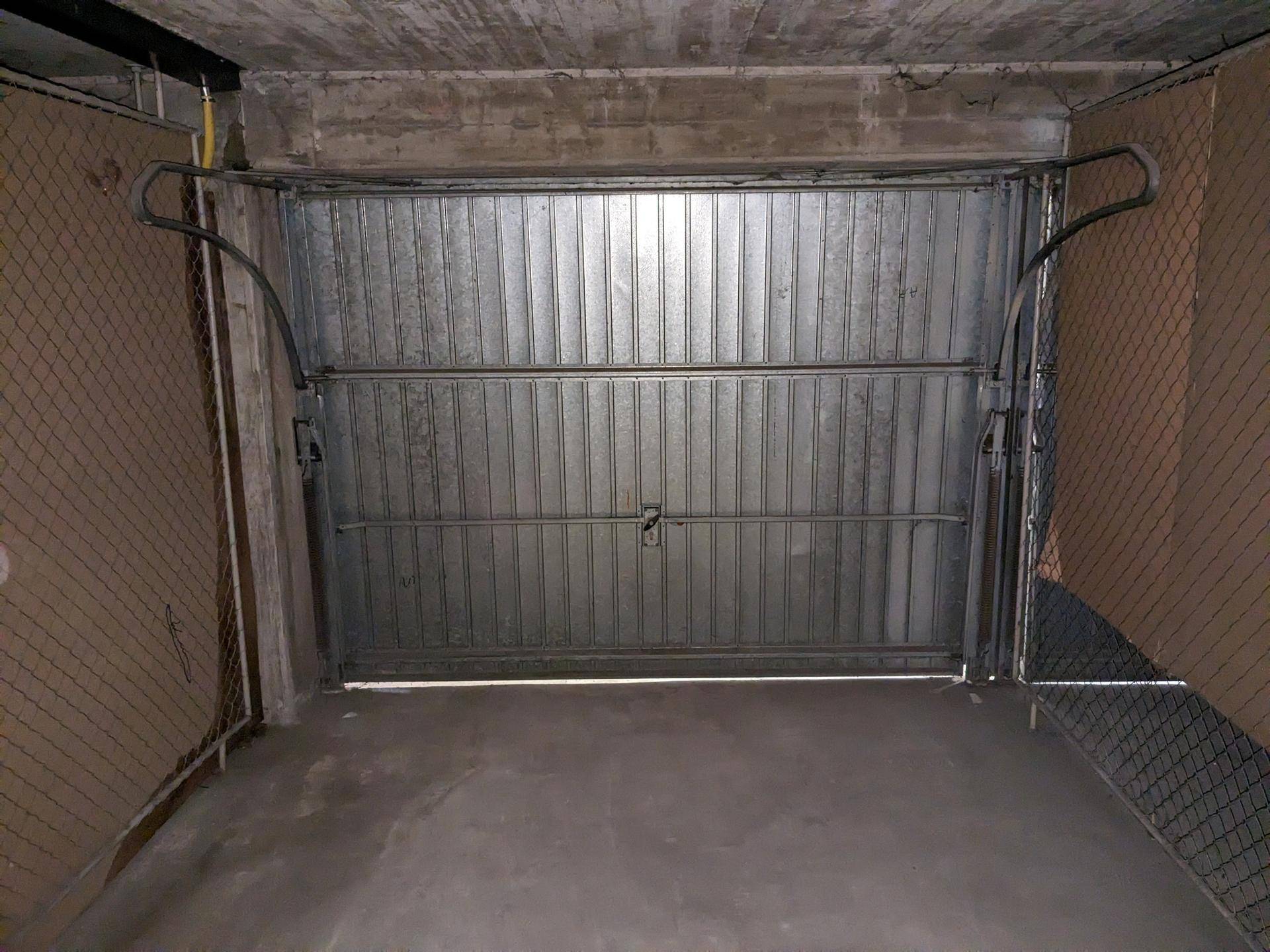 Blick aus einer Garagenbox auf das geschlossene Metalltor.