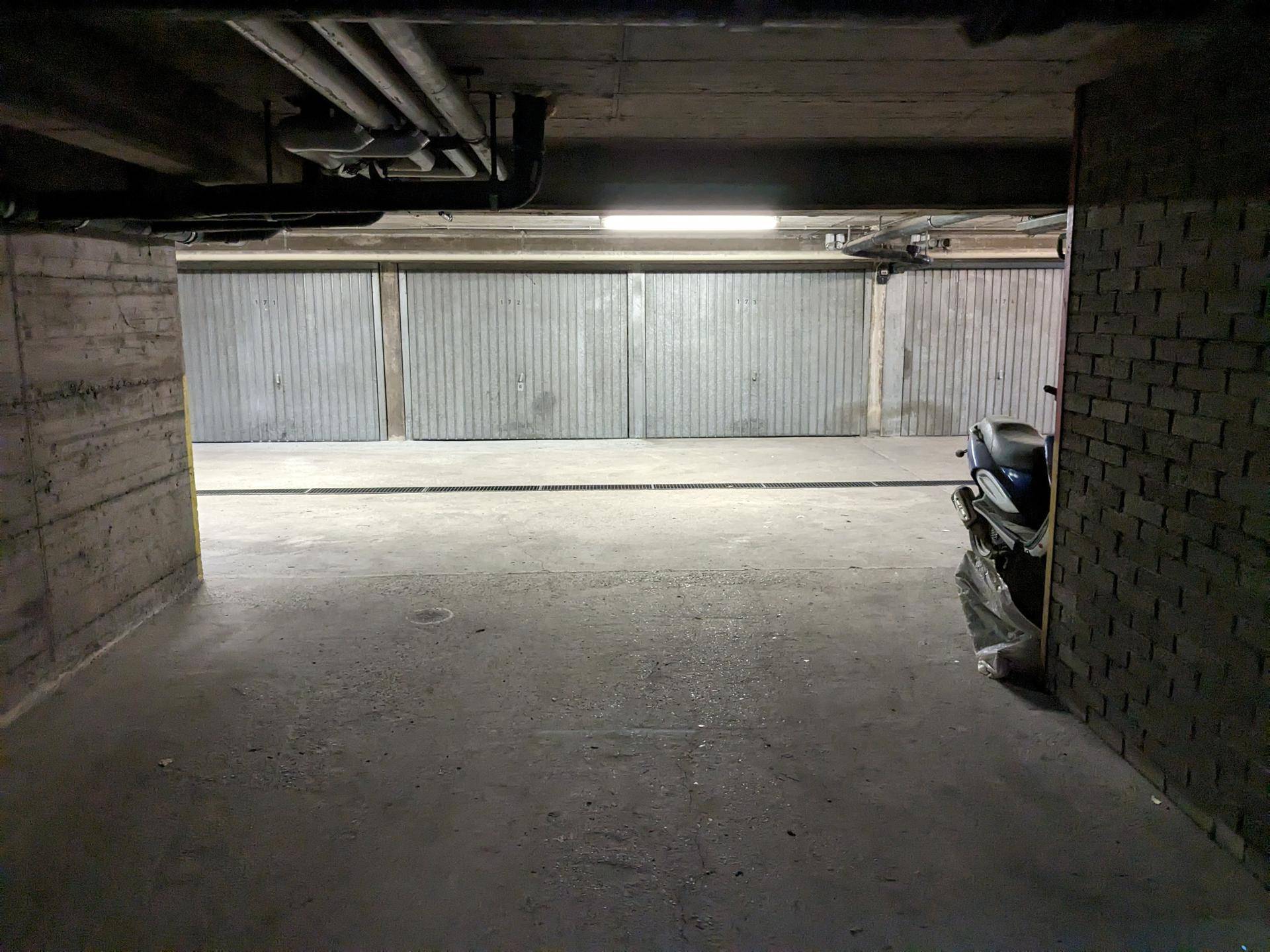 Geräumige Tiefgarage mit mehreren Einzelgaragen und Betonwänden.
