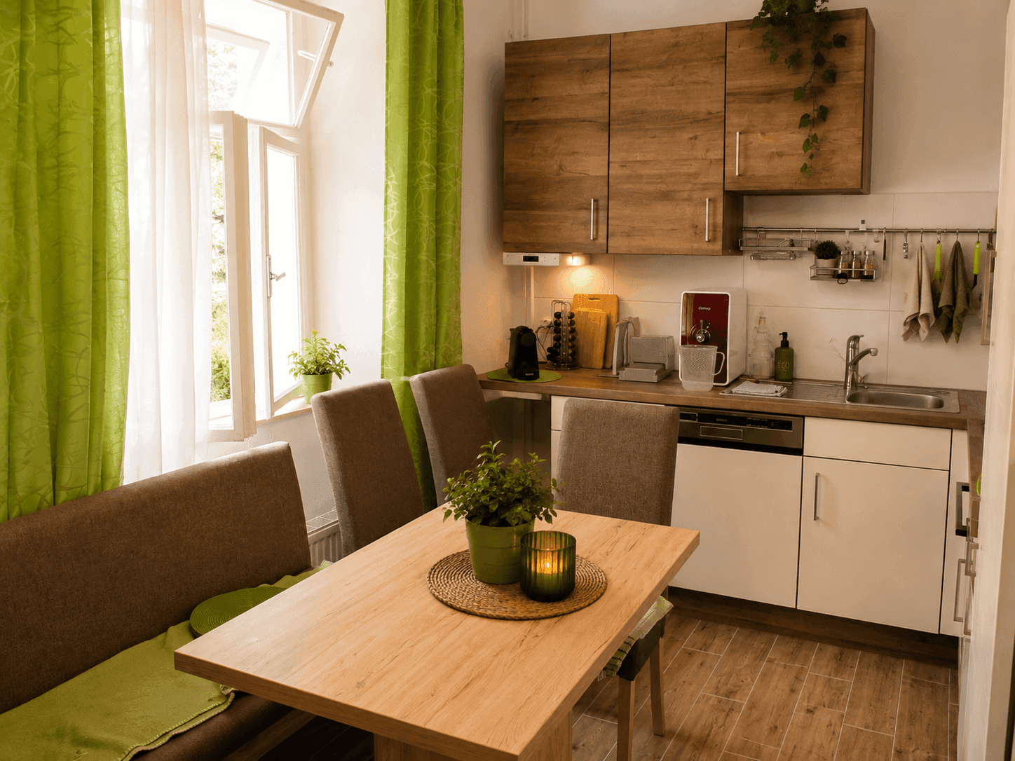 Moderne Einbauküche mit Essbereich, Holzschränken und Blick ins Grüne durch das Fenster.