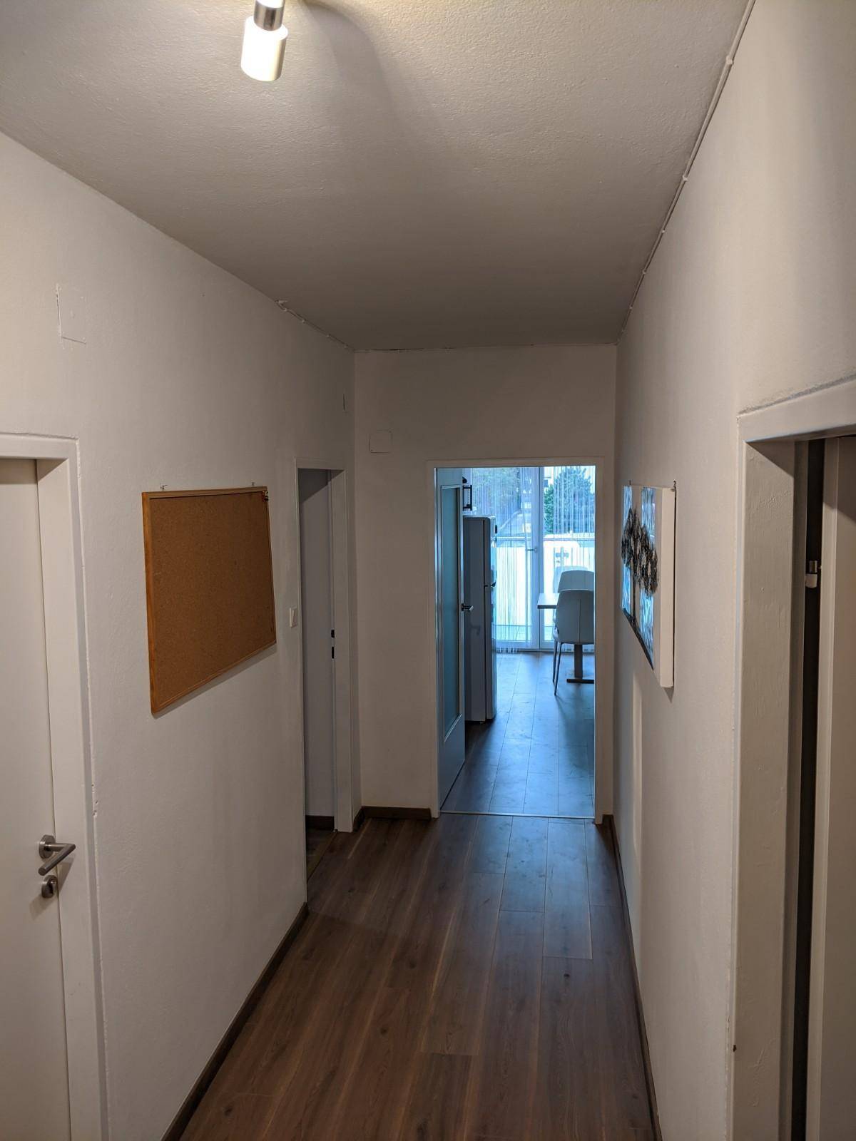 Langer Flur mit Holzboden, der zu den verschiedenen Zimmern führt.