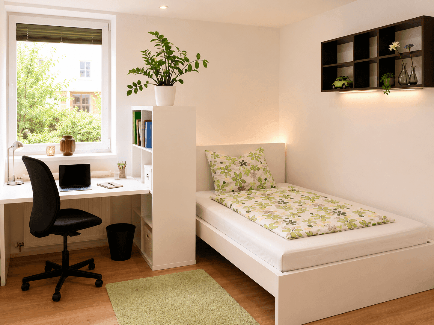 Freundliches Schlafzimmer mit Einzelbett, Schreibtisch und Pflanzen am Fensterbrett.