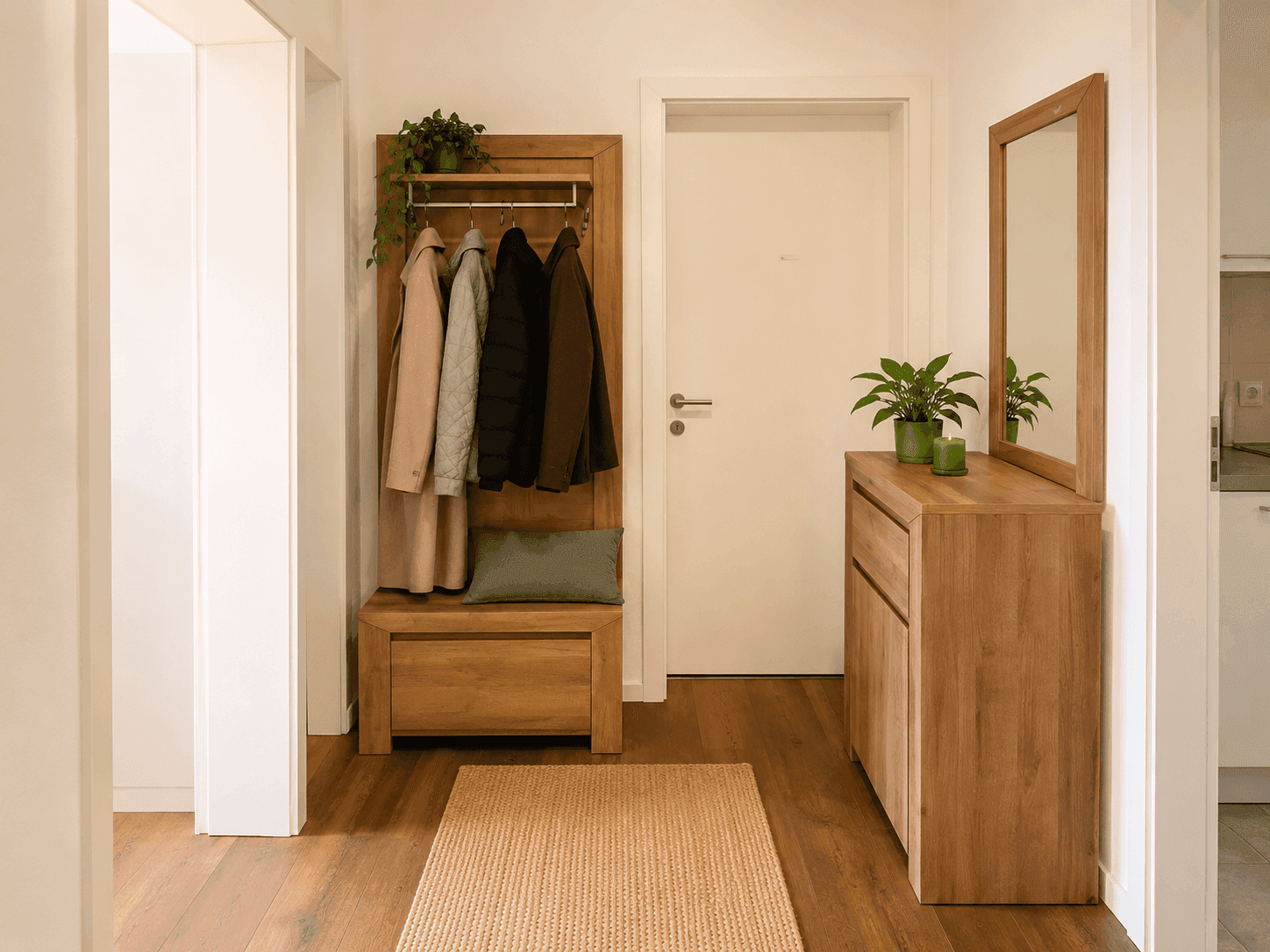 Geräumiger Flur mit Holzboden, Garderobe, Spiegel und Schuhschrank in hellem Holzdesign.