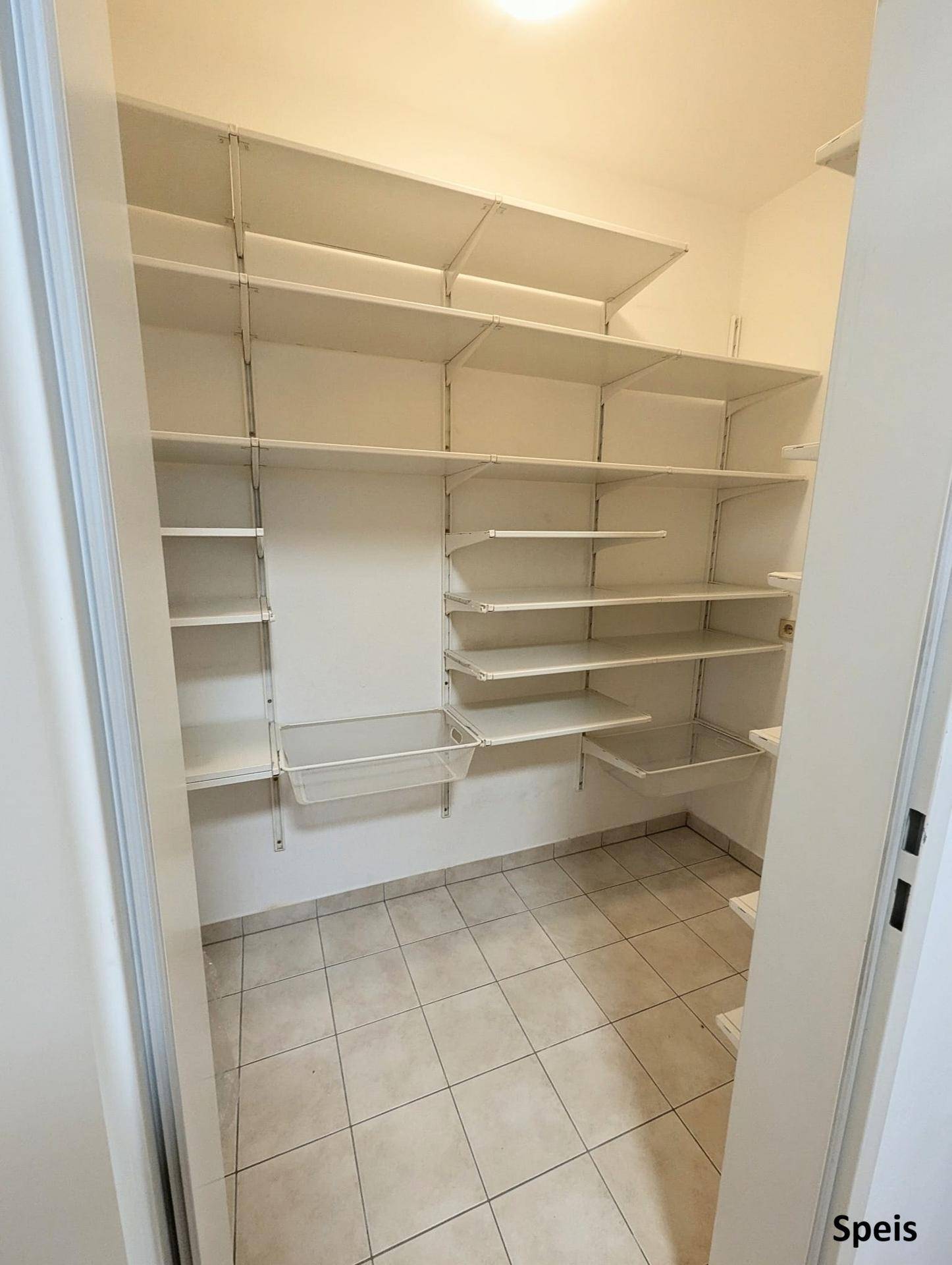 Praktische Speisekammer mit Fliesenboden und vielen Regalen für optimale Lagerung.