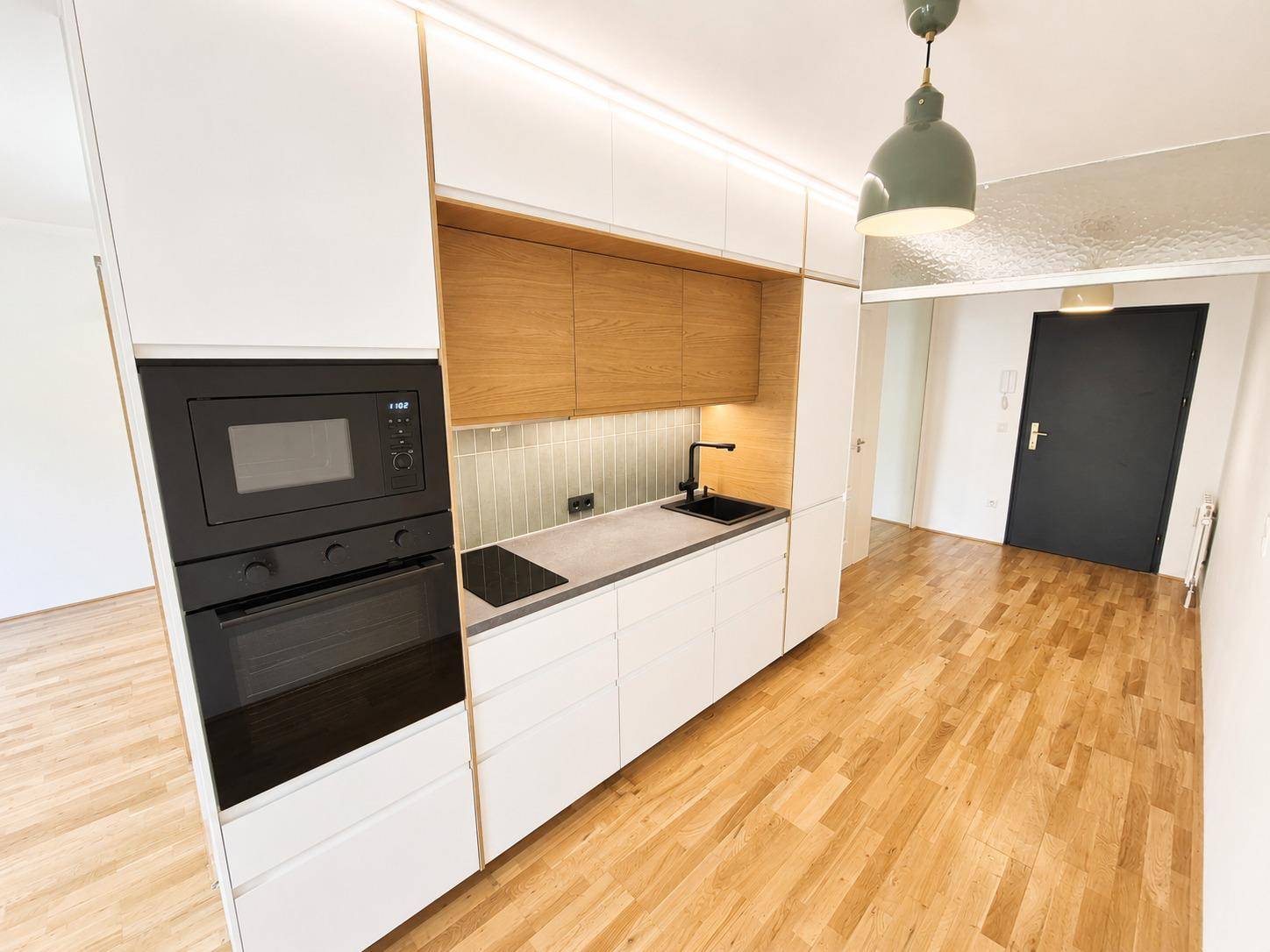 Blick auf die moderne Küchenzeile mit integriertem Backofen und Mikrowelle.